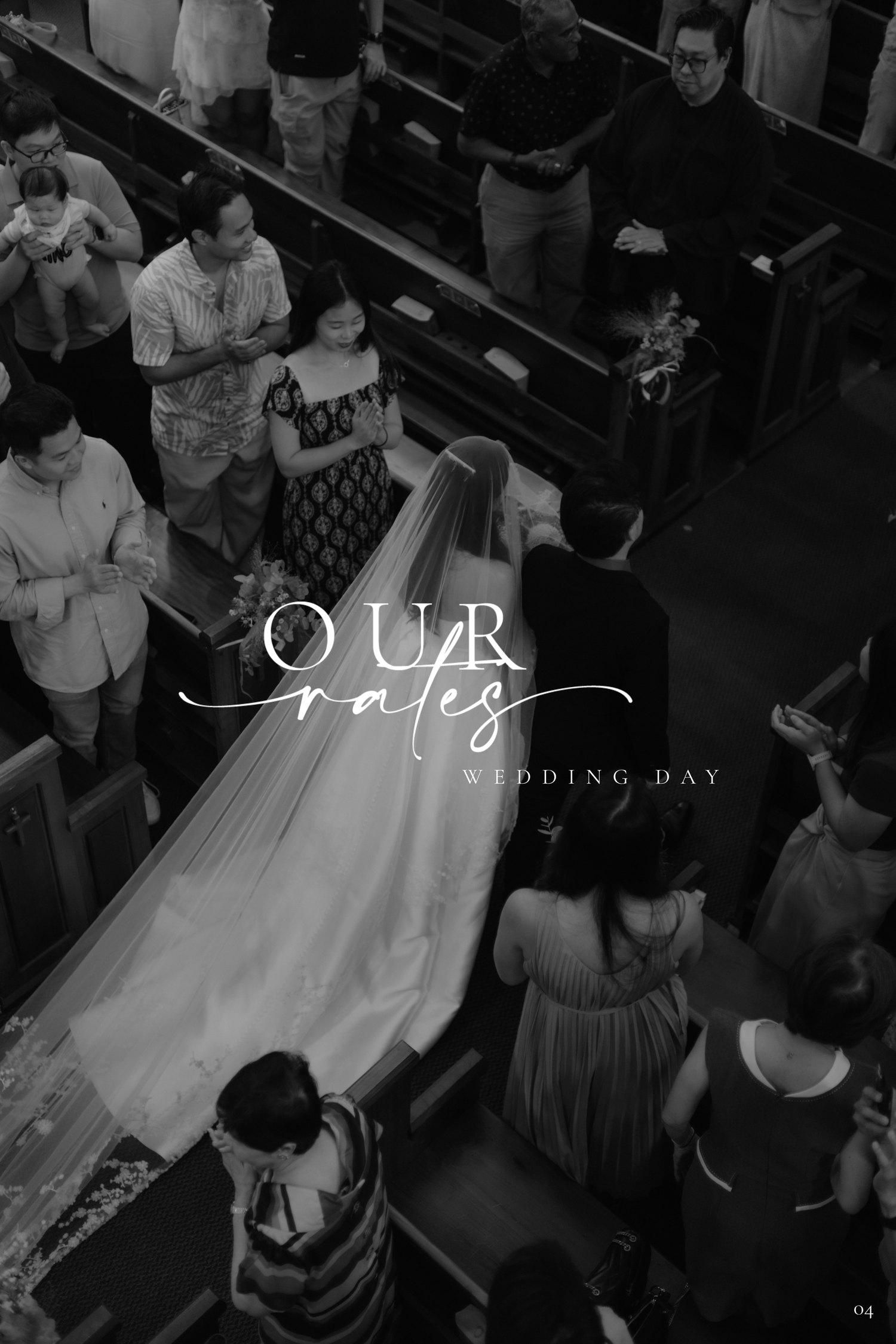 Black and white aerial view of a bride walking down the church aisle in a wedding gown with a long veil.