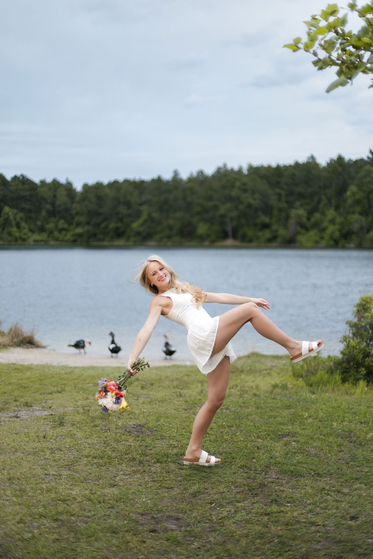 Jacksonville senior portrait of a graduating senior in a white romper near the water.