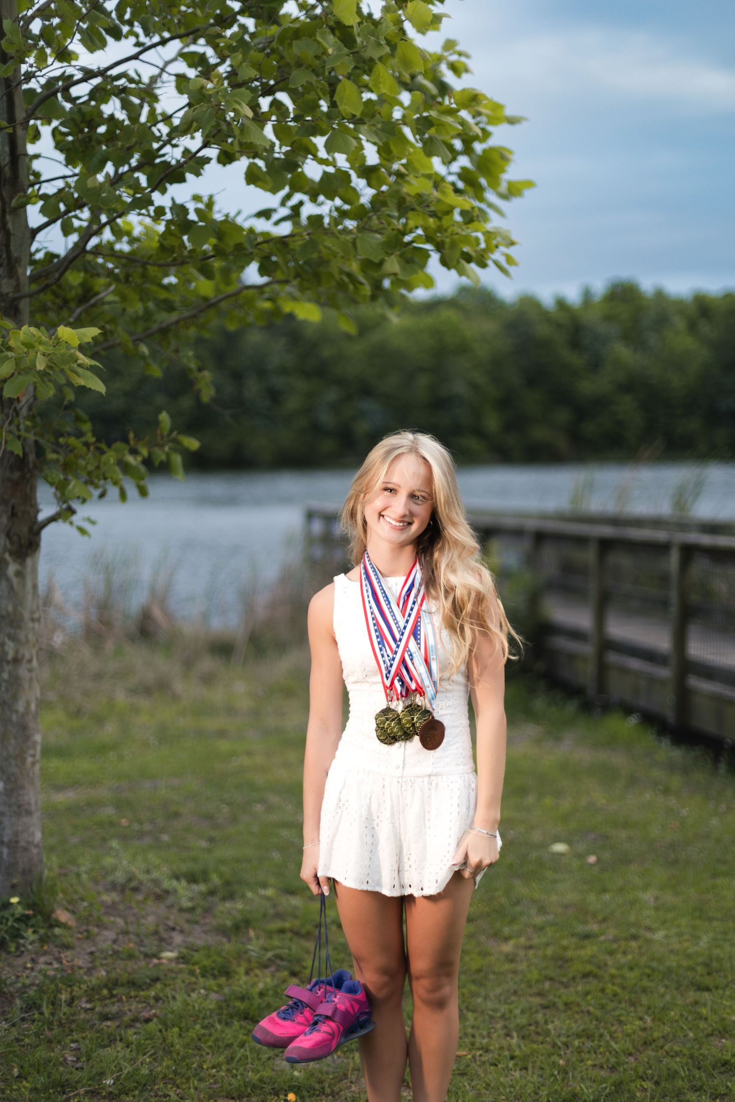 Senior athlete posing with track medals during her Jacksonville senior session.