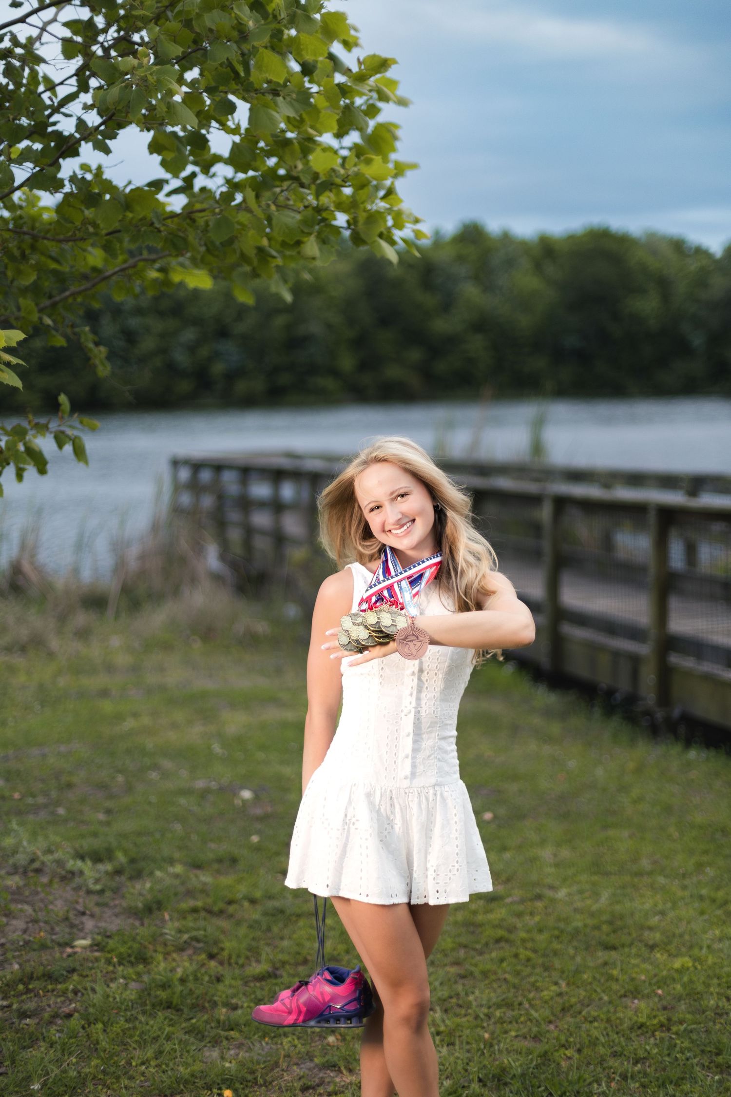 High school track athlete showing off her accomplishments during senior portraits at Sheffield Regional Park.