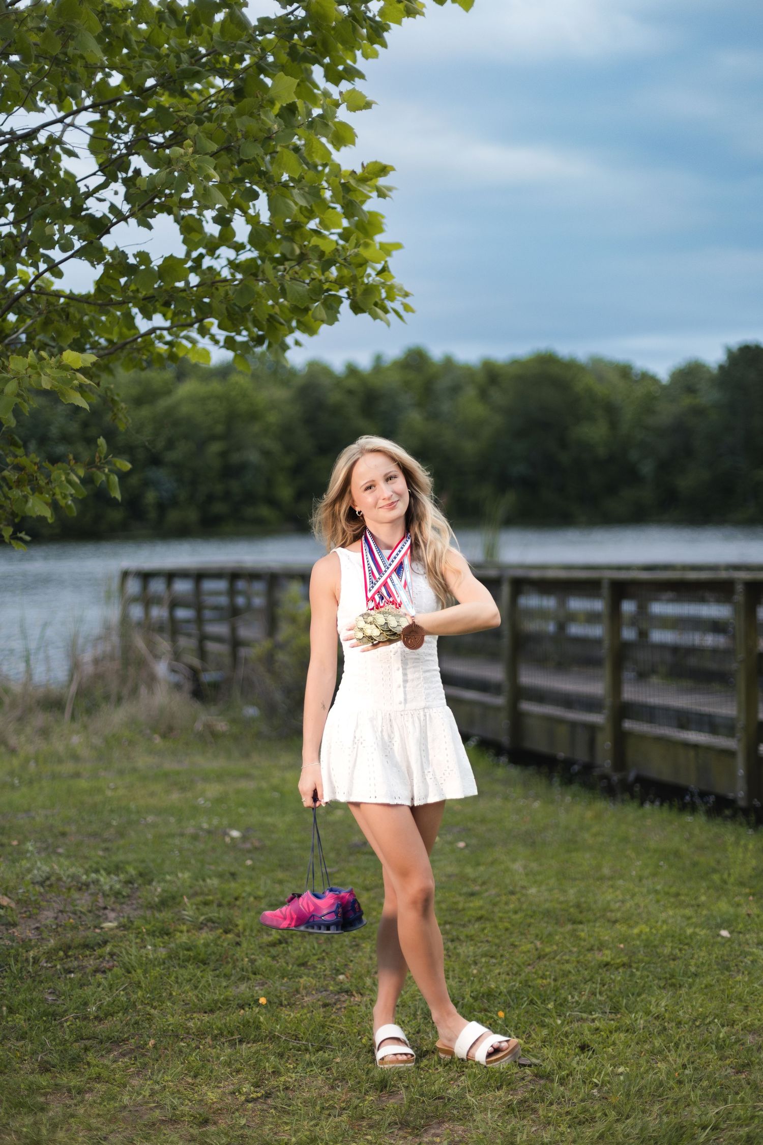 Jacksonville senior photographer capturing senior athlete portraits with track medals.