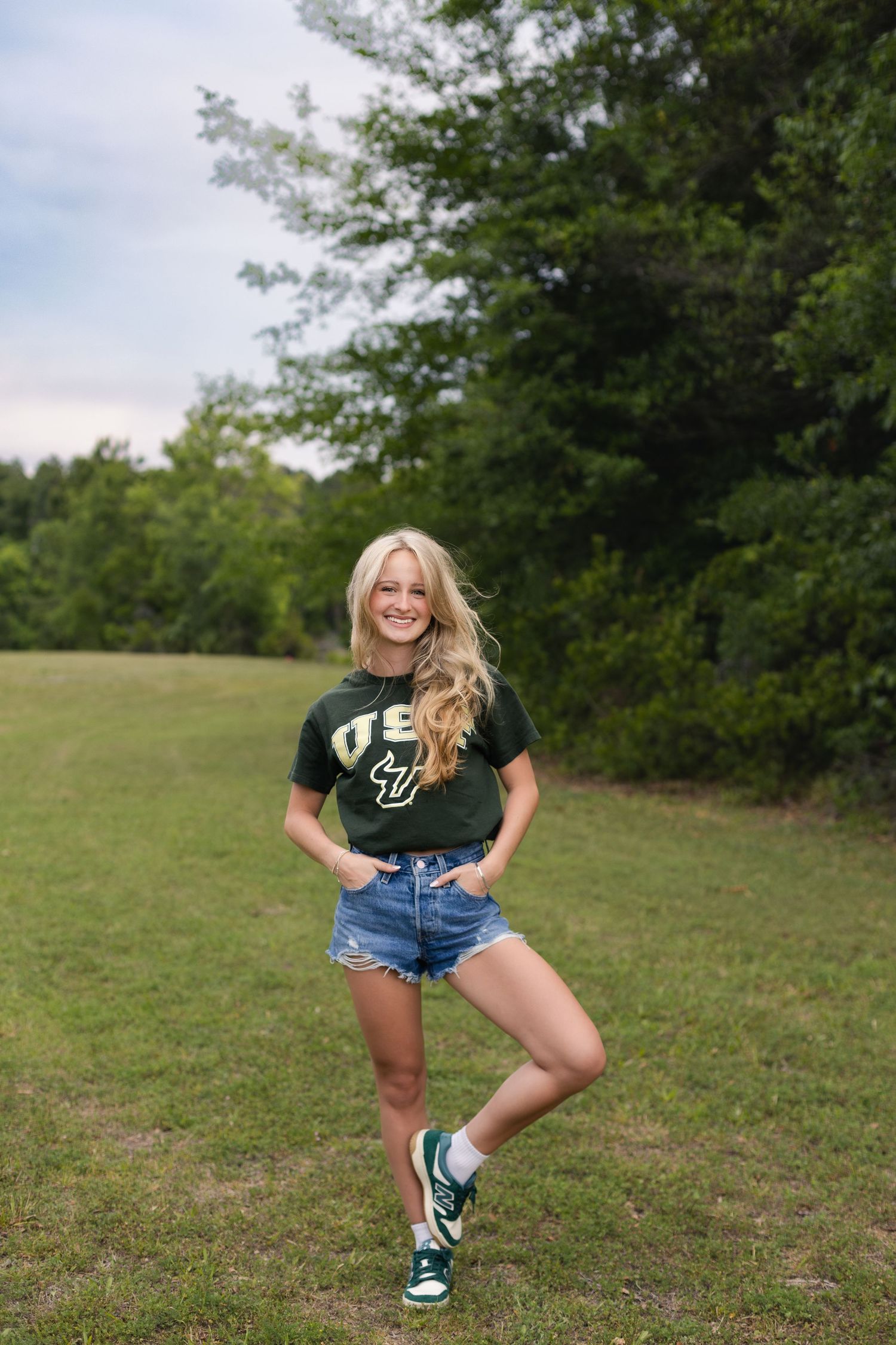 Jacksonville senior photographer capturing natural senior portraits in a wide open field.