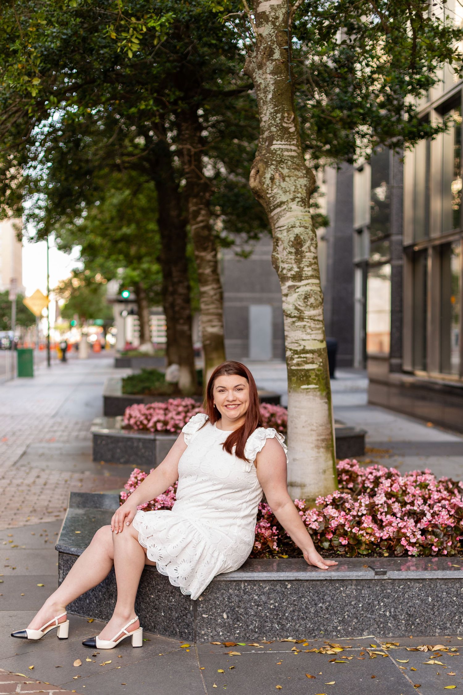 Graduate woman poses along Downtown Jacksonville sidewalk in front of Jacksonville University College of Law.