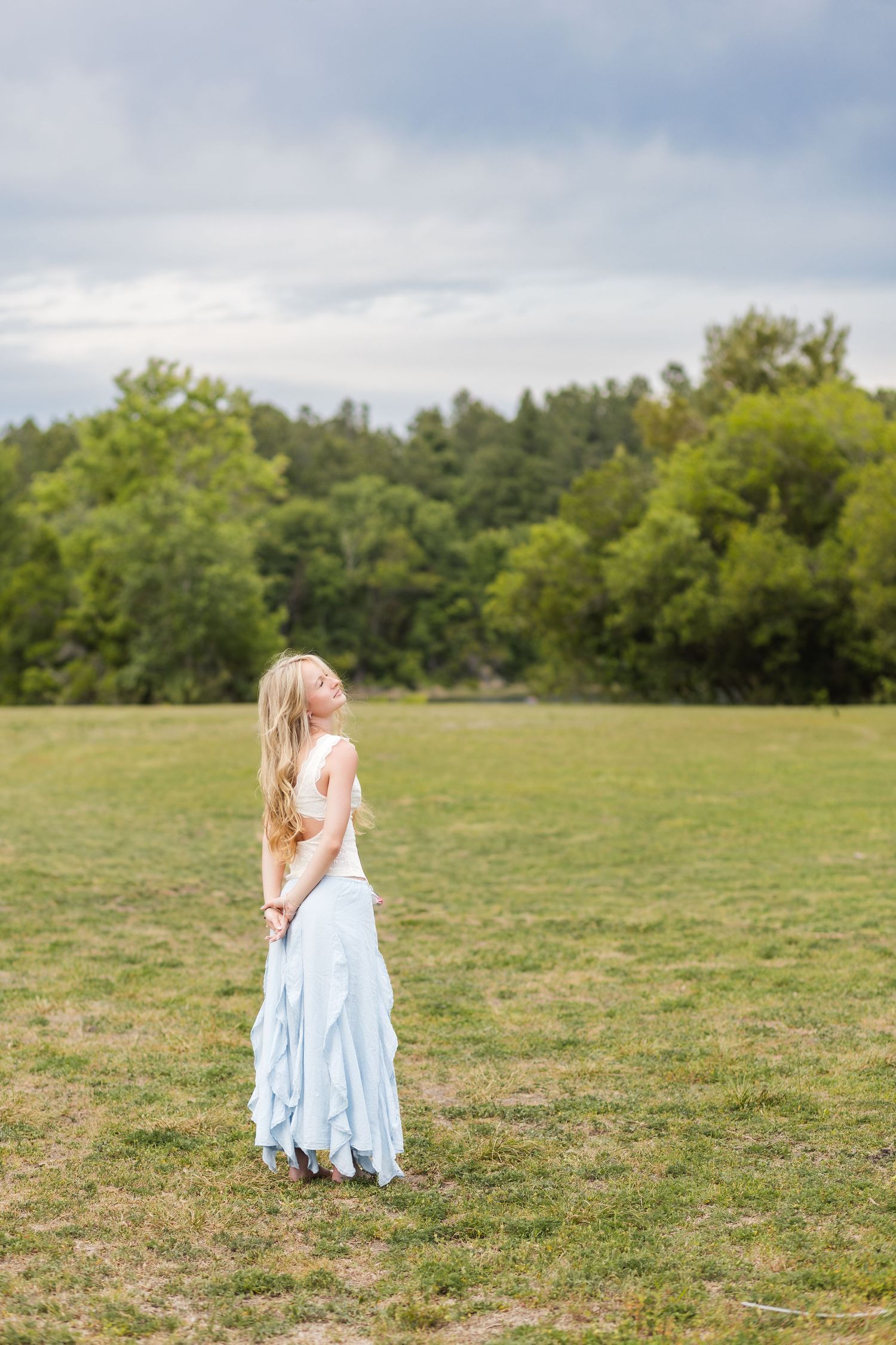 Nease High School senior standing in an open field during her Jacksonville senior portrait session.
