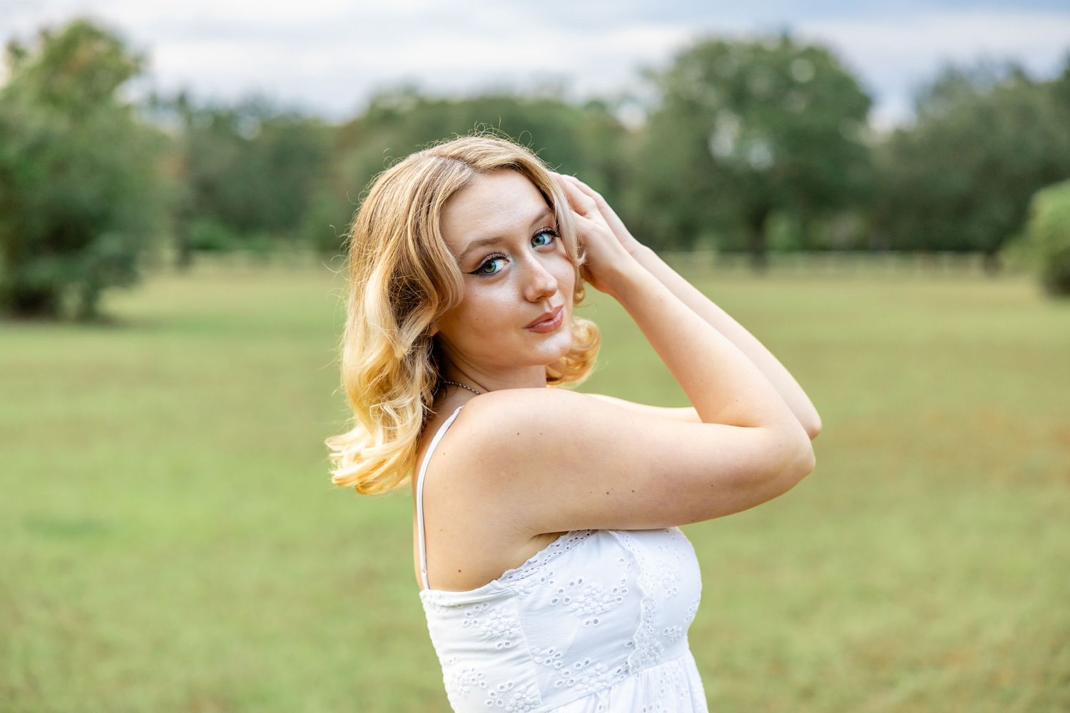 Senior girl poses in field at Camp Milton Historic Preserve.