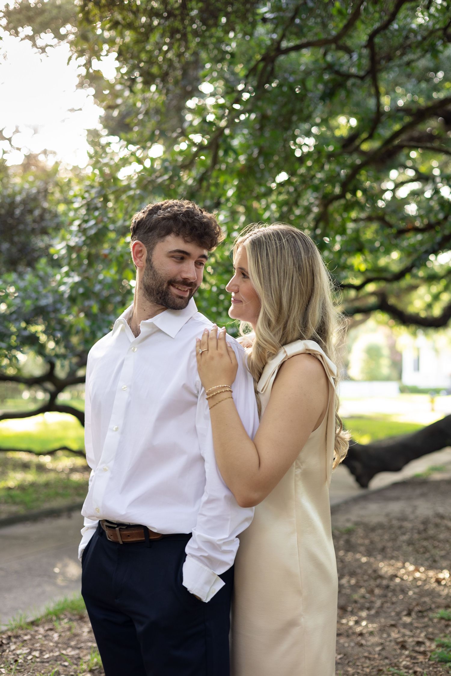 Engaged couple embracing under trees during Huntsville Alabama engagement session