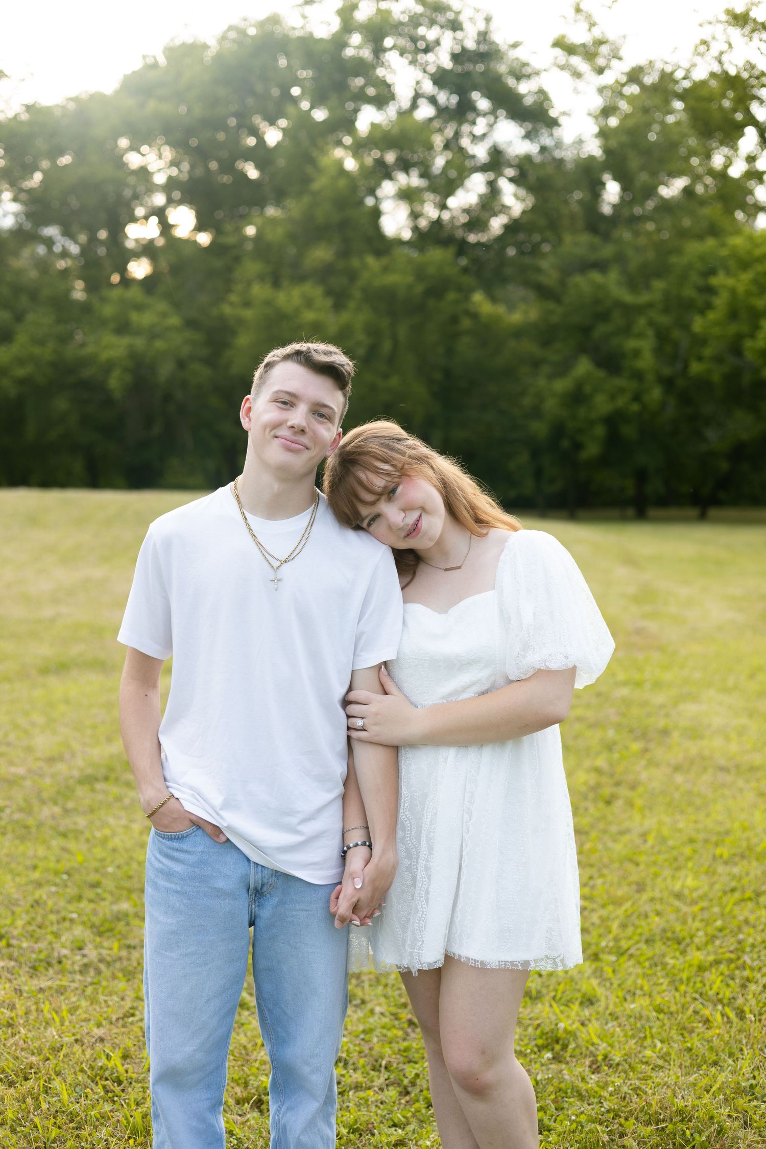 Couple embracing outdoors in a grassy field, Huntsville Alabama engagement photographer