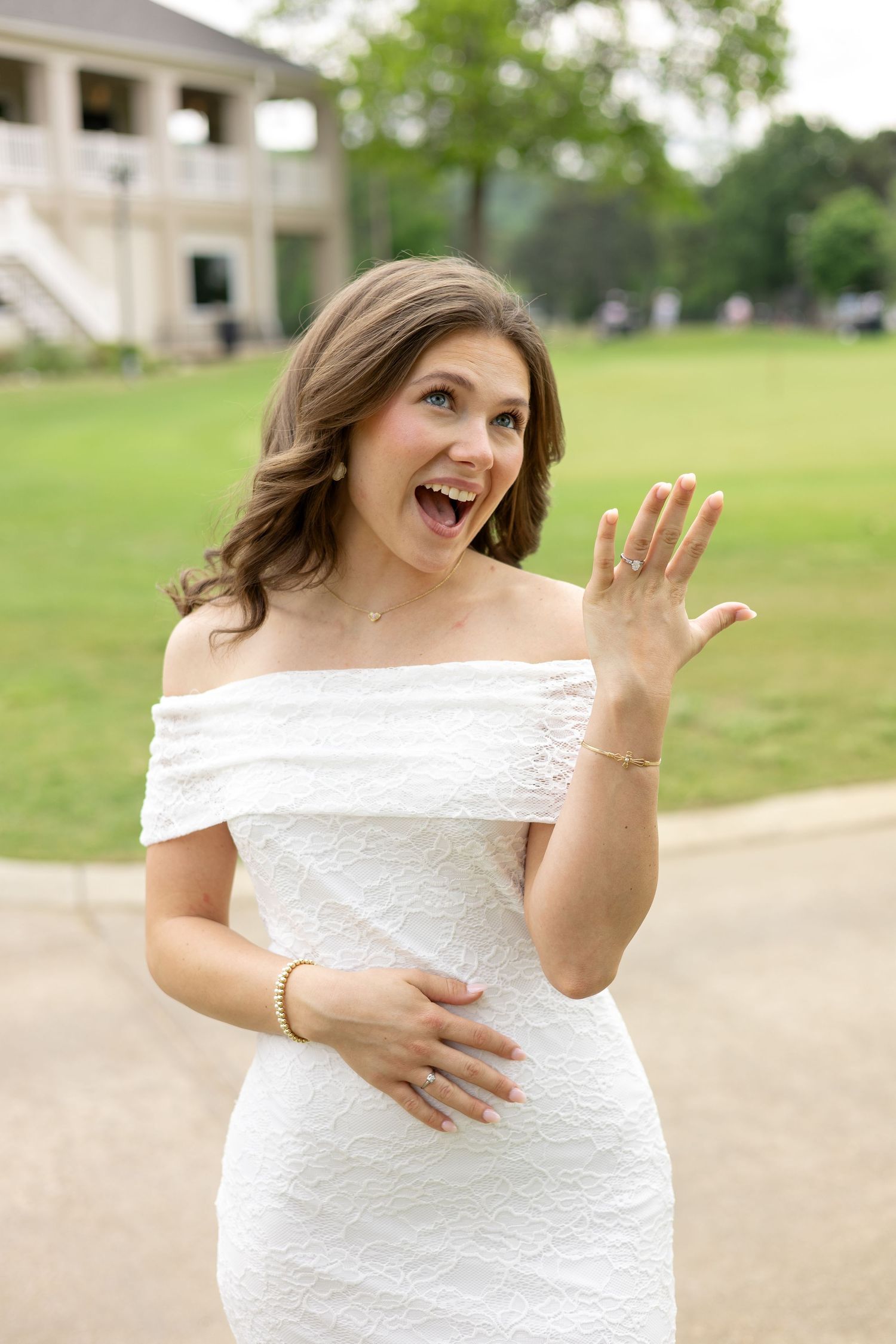 Woman in a white dress waving and smiling outdoors, Huntsville Alabama individual portrait session