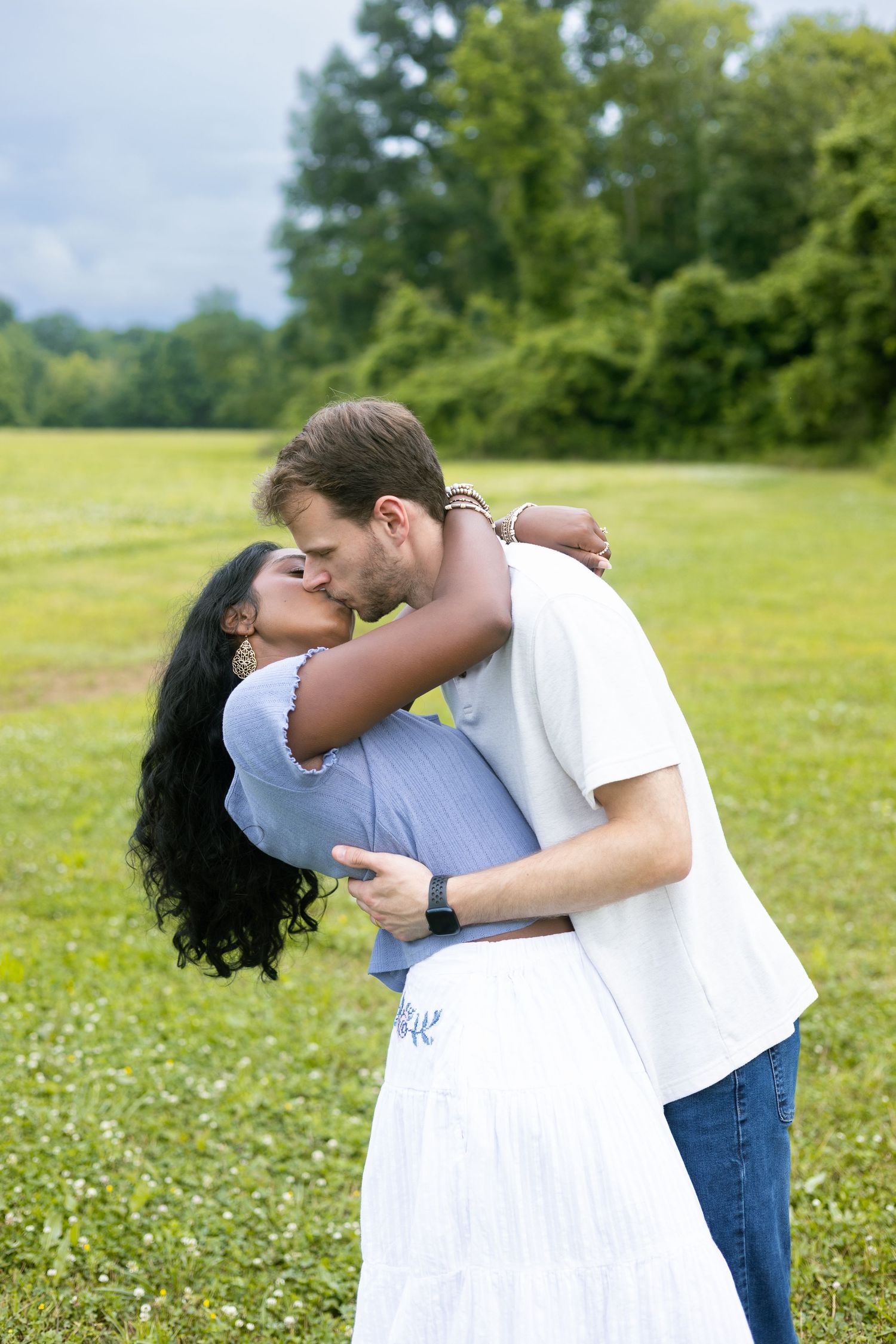 Couple embracing in a grassy meadow, North Alabama engagement session