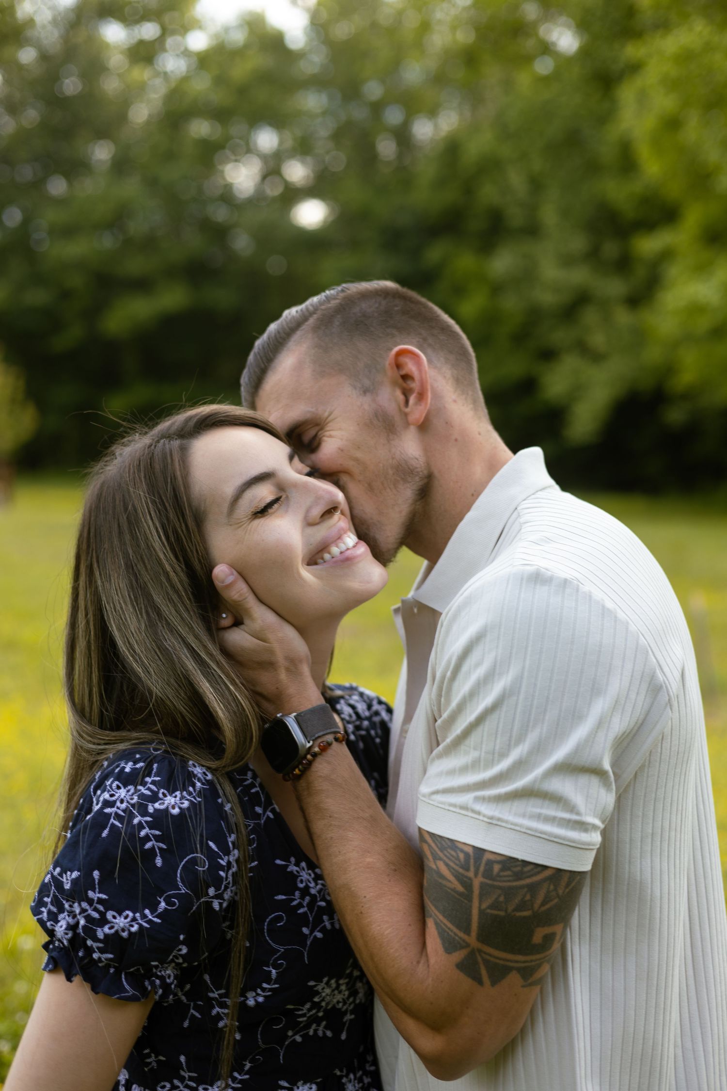 Couple embracing outdoors in a green field, Huntsville Alabama engagement session