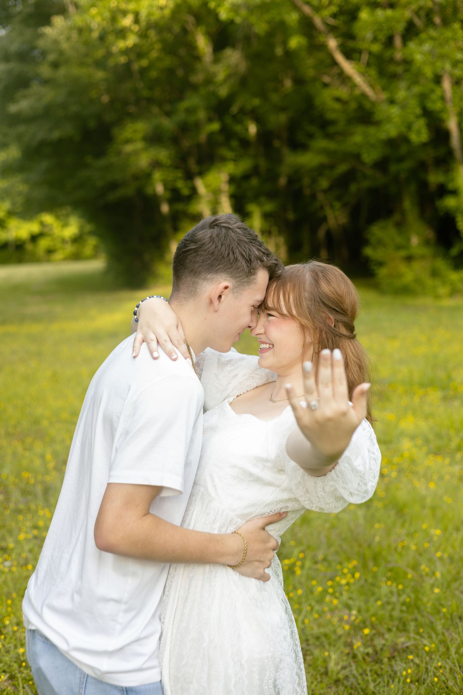 Couple sharing a kiss outdoors in a green field, Huntsville Alabama engagement session