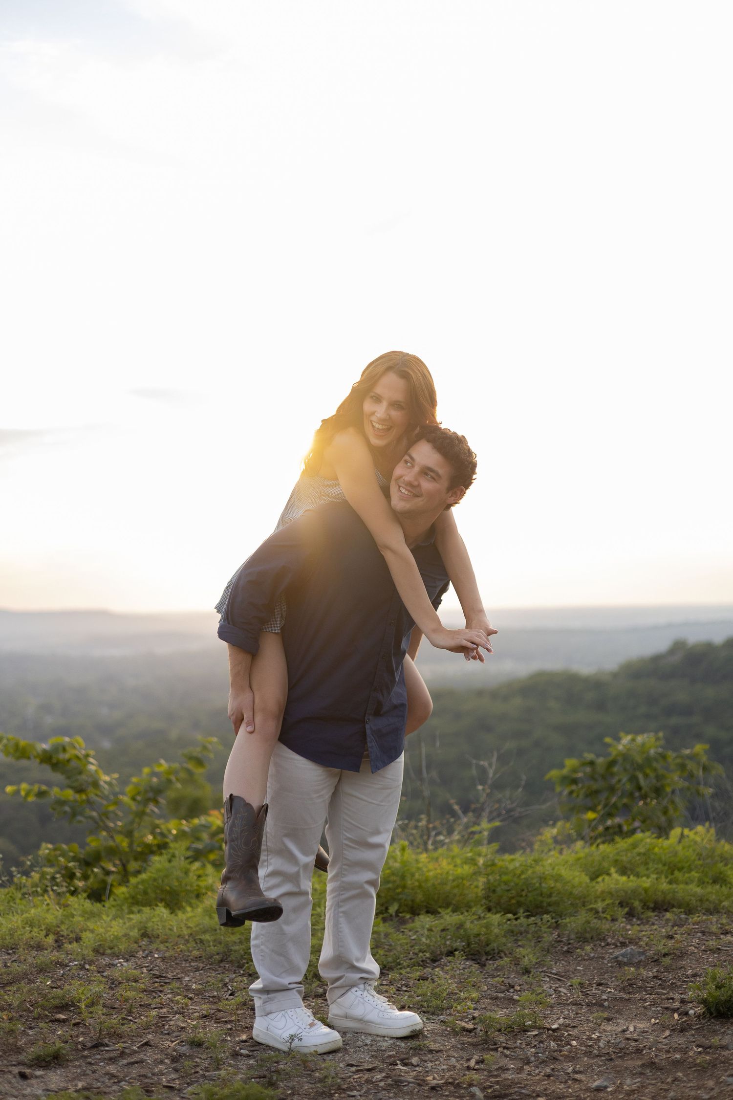 Man playfully carrying his fiancée on a mountain overlook, Huntsville Alabama engagement session
