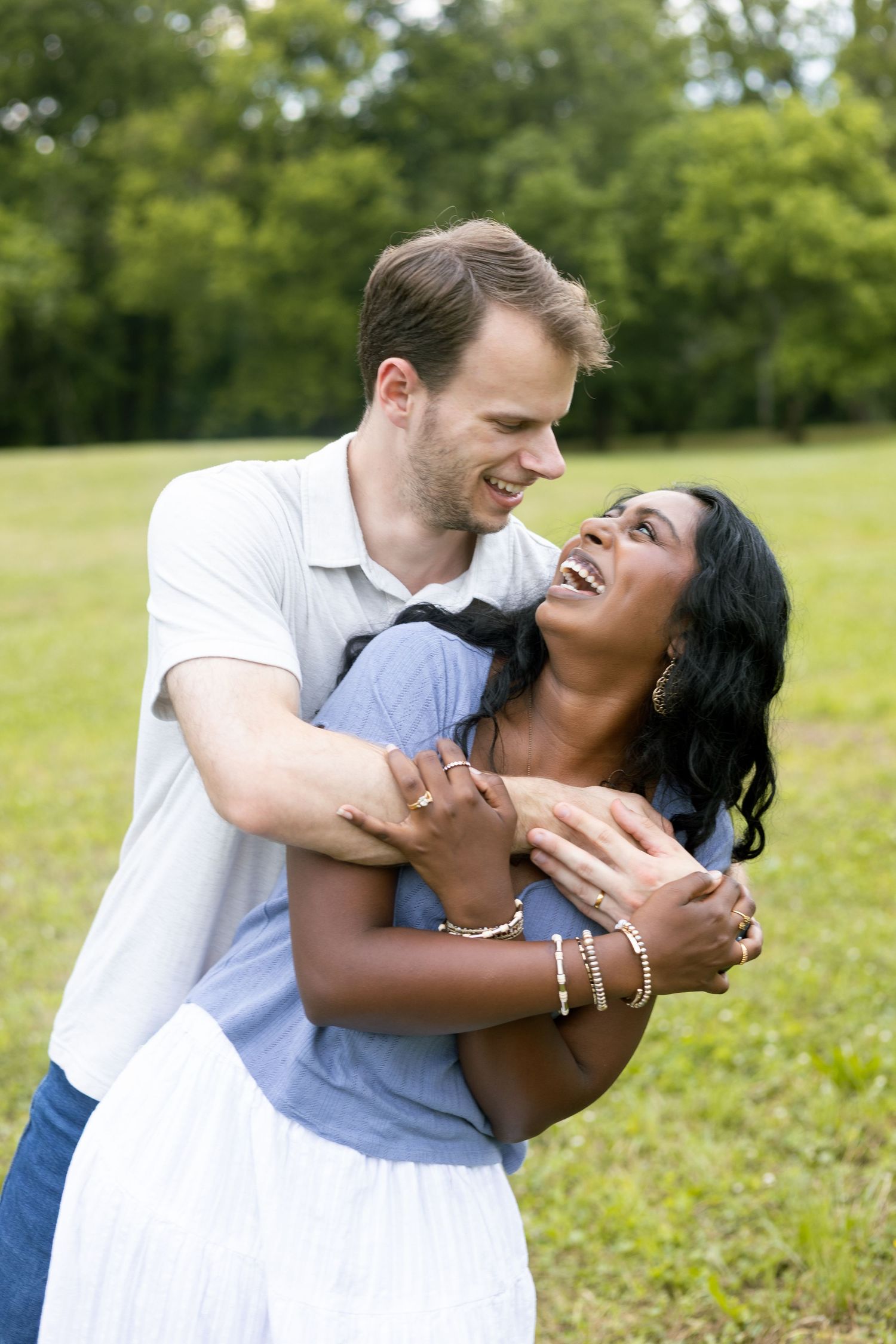 Couple hugging outdoors in a green field, Huntsville Alabama lifestyle photography session