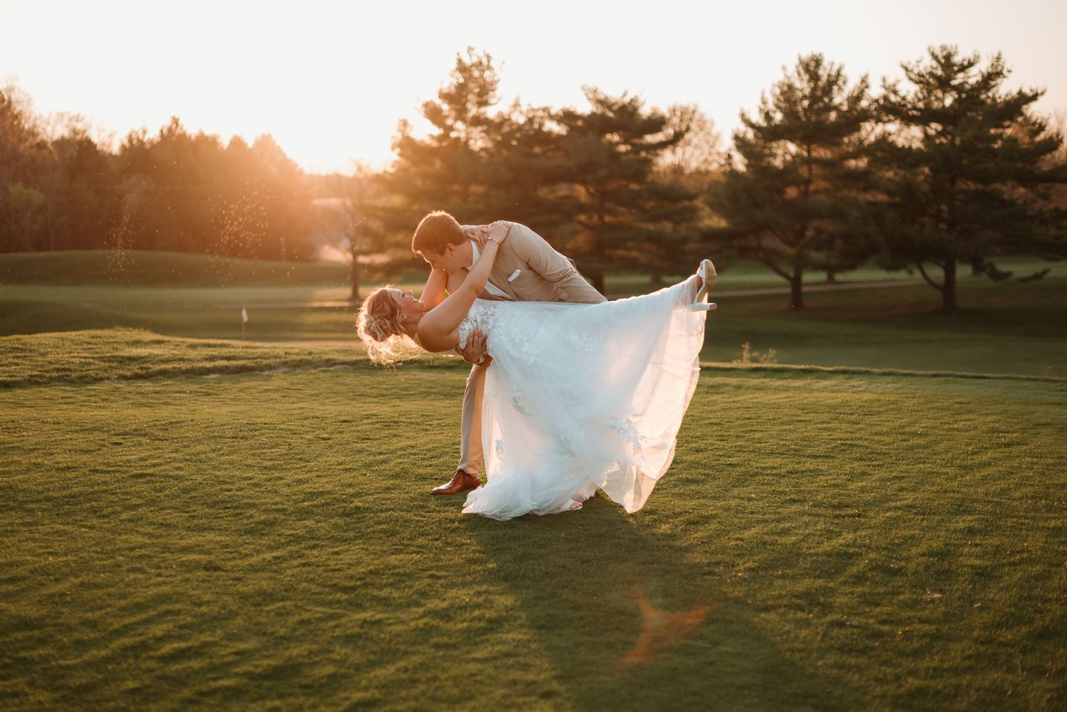 Couple dipping on the golf course during sunset photos at Stonebrook Golf Club in Minnesota