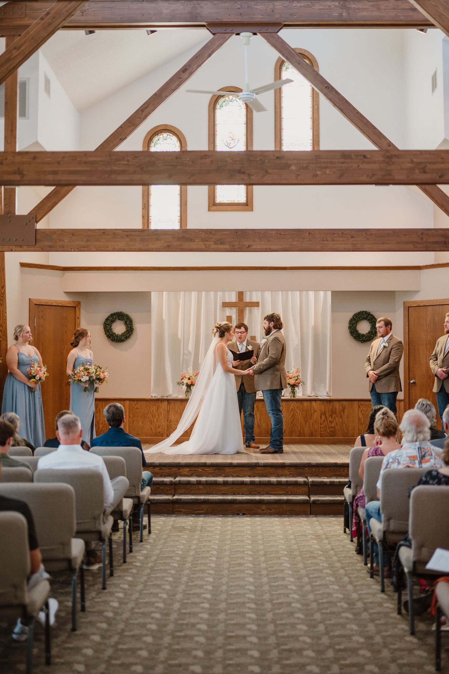 Newlyweds holding hands during their wedding ceremony in their church in Minnesota