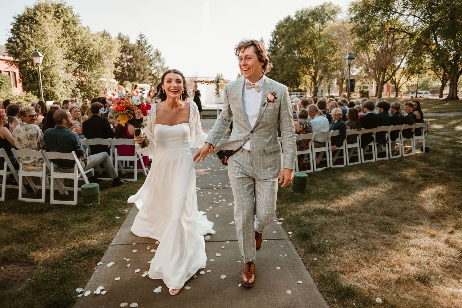 Bride and groom laughing together during their ceremony exit at The Heritage Center of Brooklyn Center