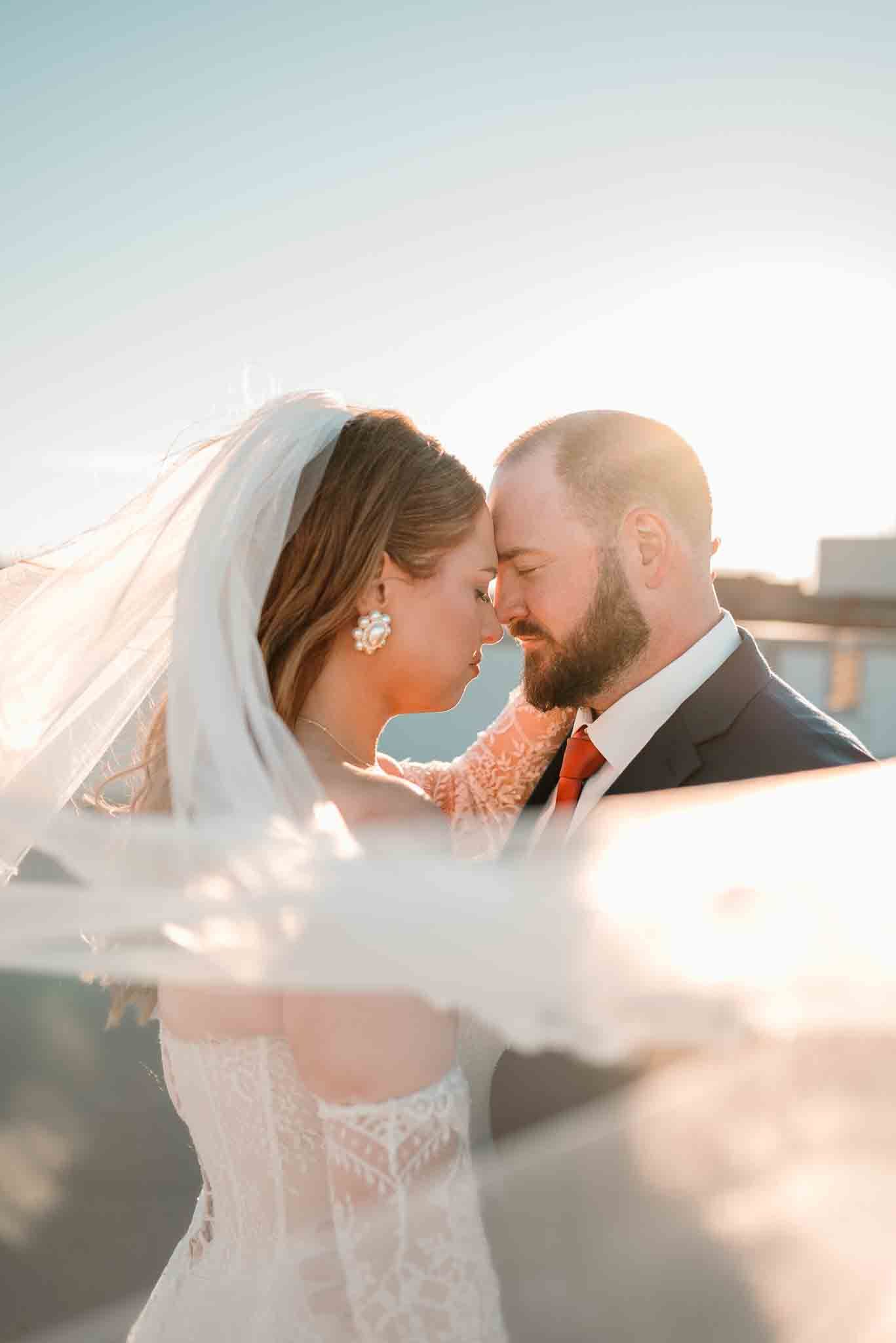 Bride and groom sharing a kiss during golden hour wedding portraits in Grand Forks, ND