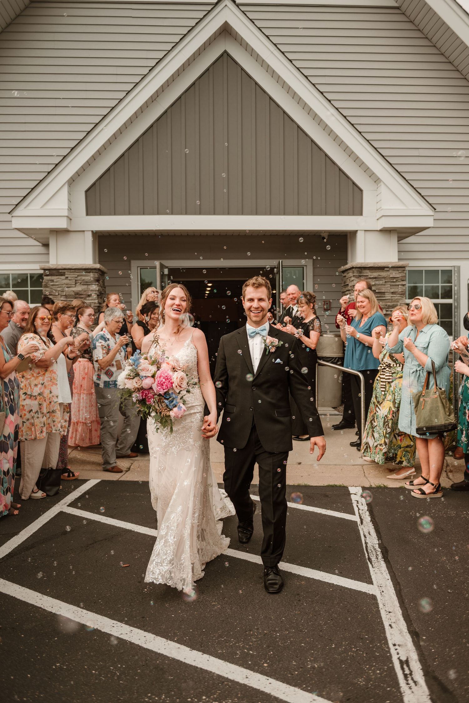 Couple exiting church with blowing bubbles after their ceremony in Minnesota