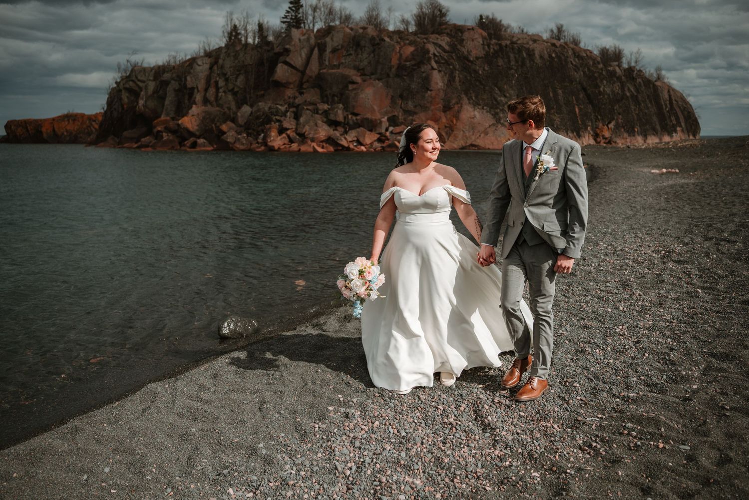 Newlyweds walking on the beach during wedding portraits in northern Minnesota