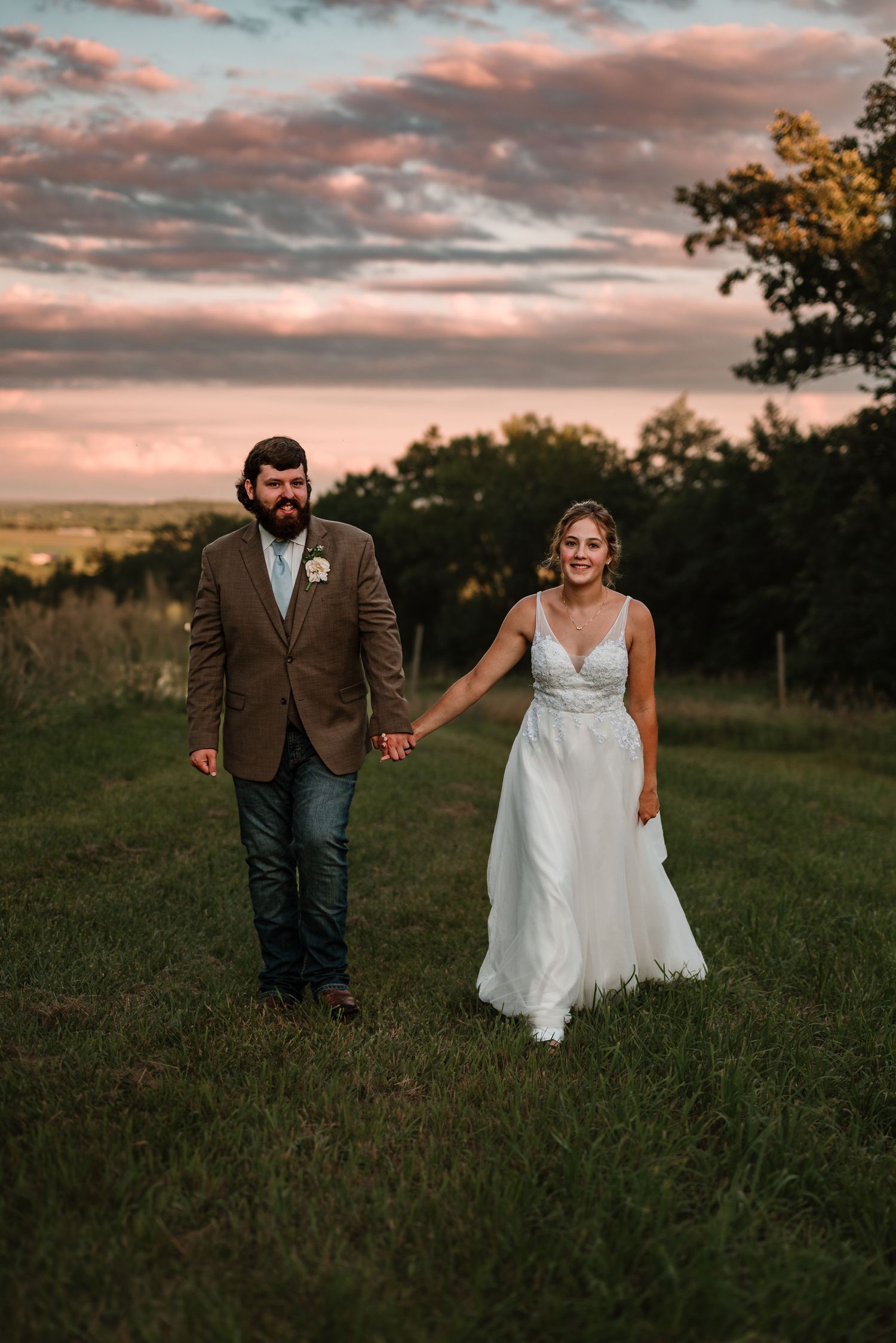 Bride and groom running through a field during golden hour in Minnesota