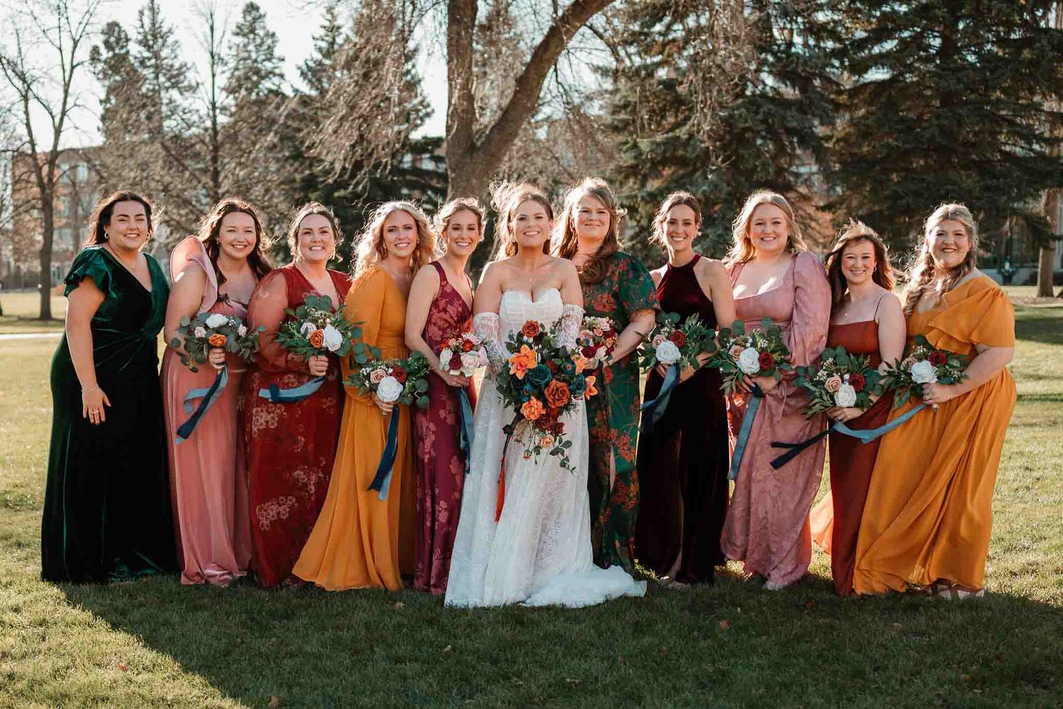 Bride laughing with her bridesmaids in the afternoon sun in Grand Forks