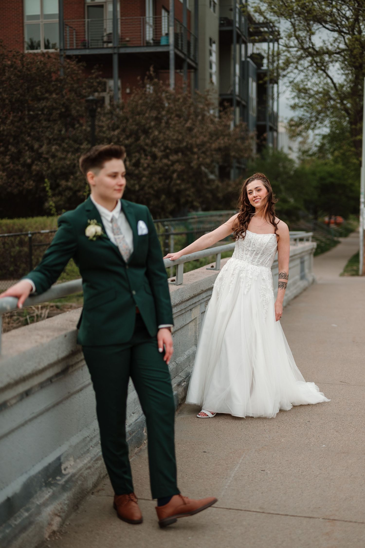 Two brides leaning against a railing in uptown Minneapolis, wedding at Five Event Center