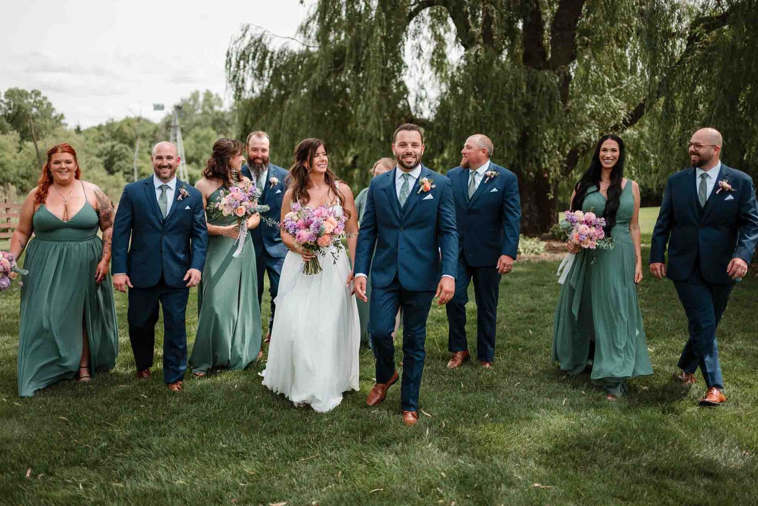 Wedding party walking together during relaxed outdoor portraits at Harvest Moon Pond in Poynette Wisconsin