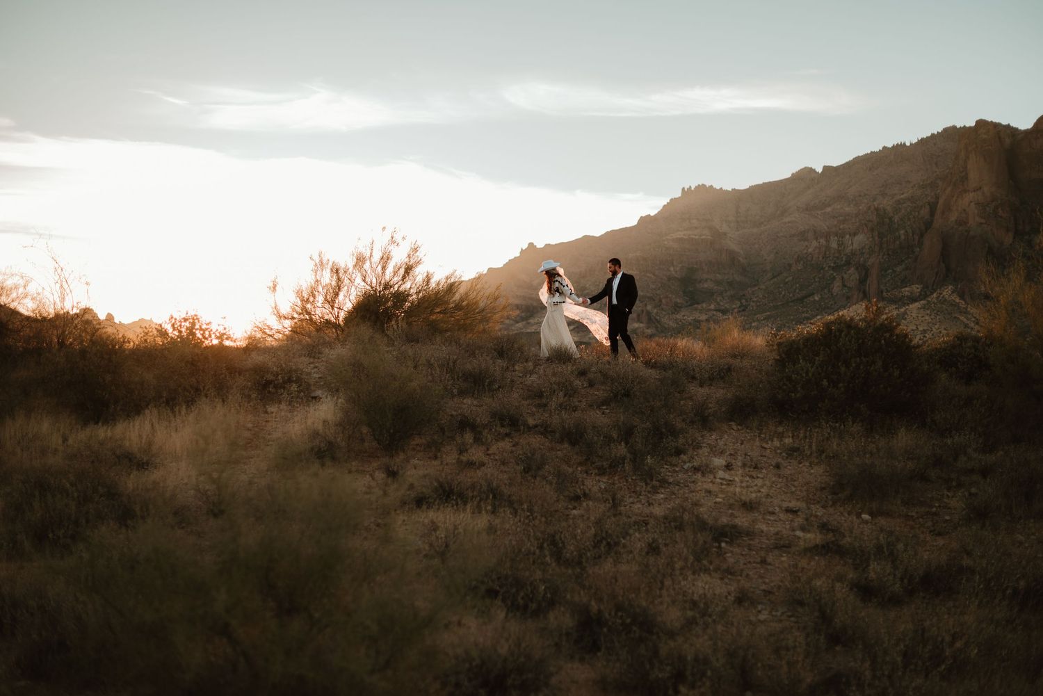 Couple walking through the desert at sunrise during their elopement in Arizona