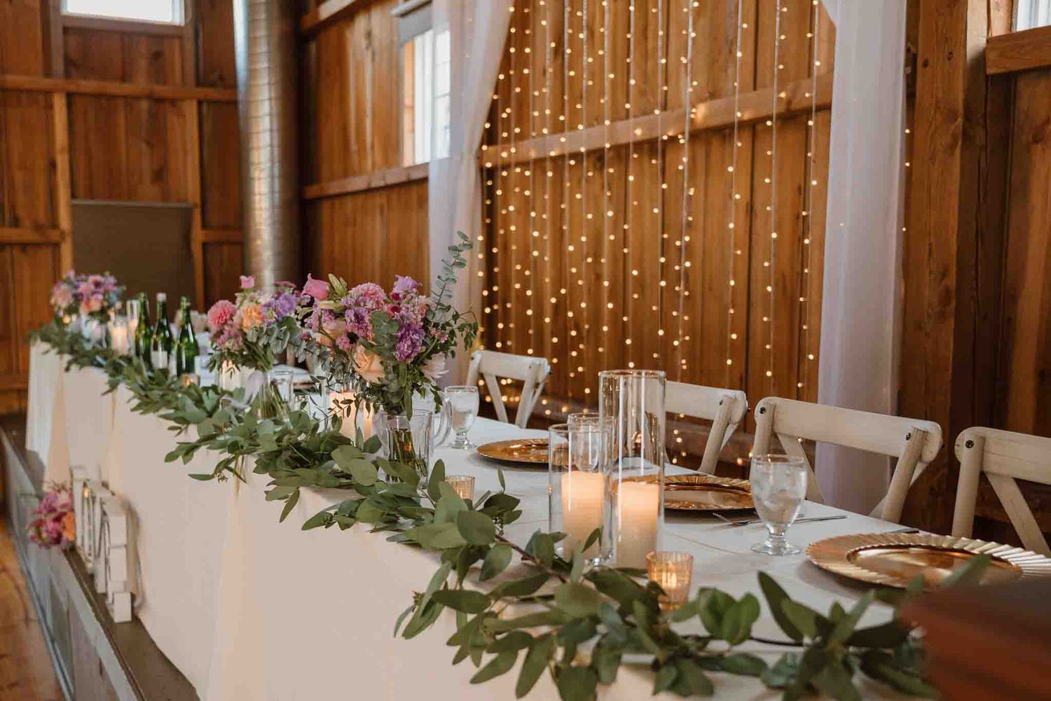 Wedding reception tables decorated with candles and floral arrangements at Harvest Moon Pond