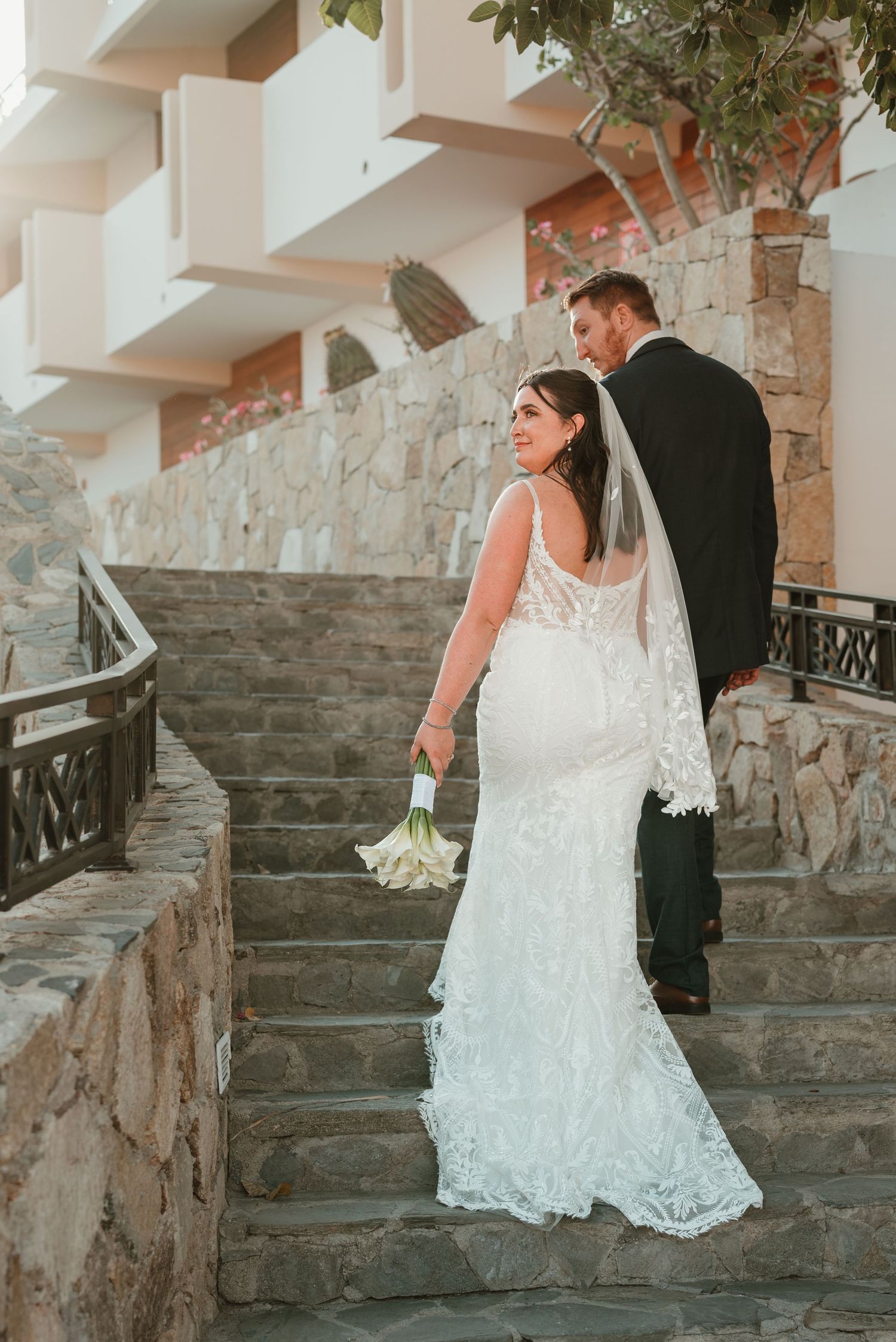 Couple walking up stairs in Cabo at their destination wedding at Sandos Finnestera