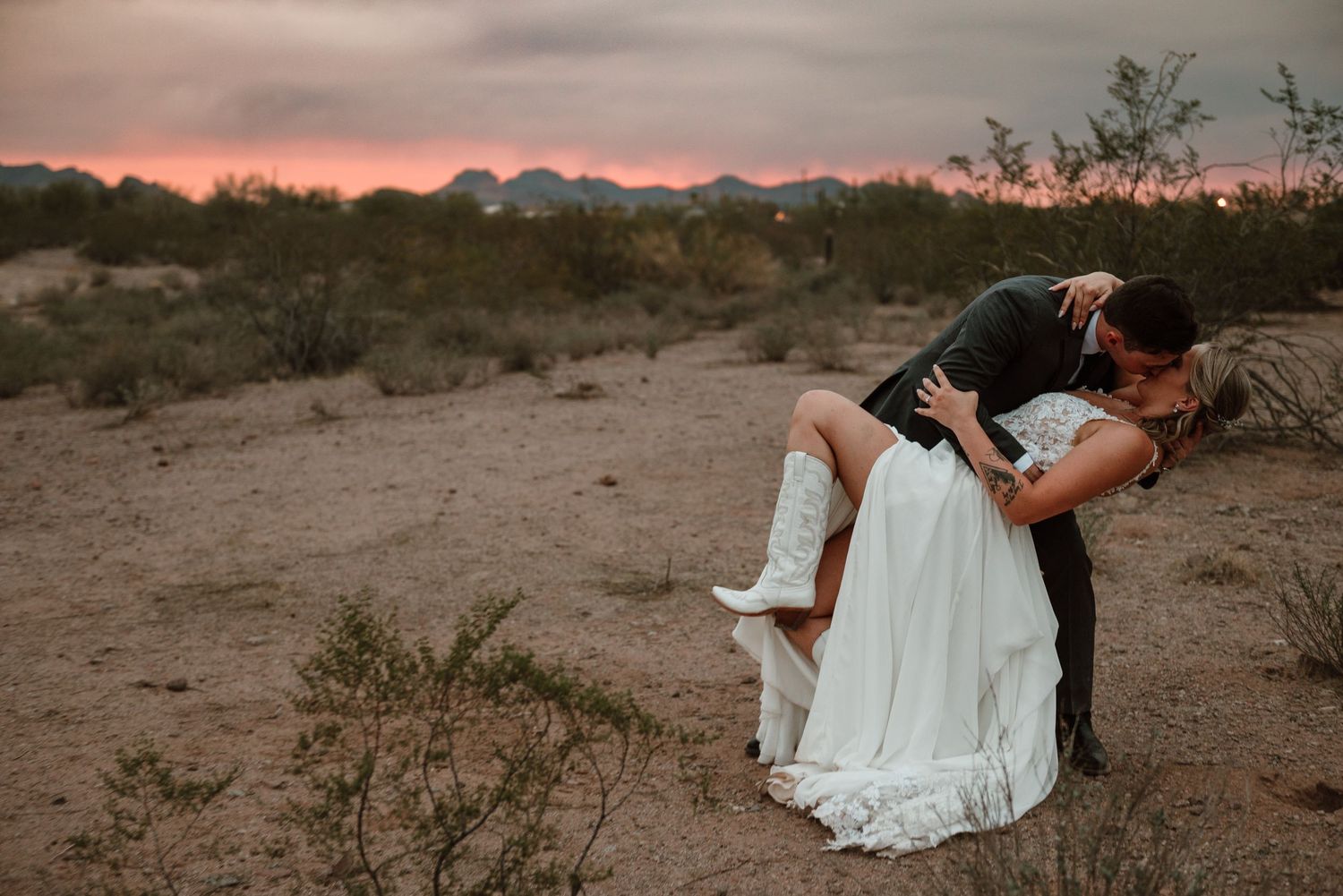 Couple dipping into a kiss during sunset photos at their wedding in Arizona at Desert View