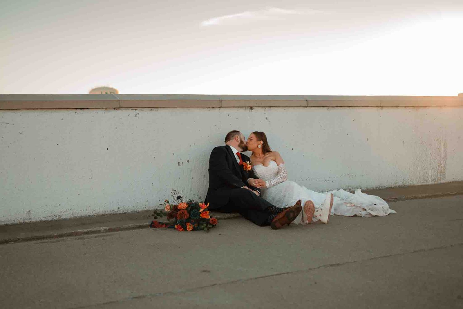 Newlyweds sharing a candid laugh in soft golden evening light on the parking garage during their North Dakota wedding