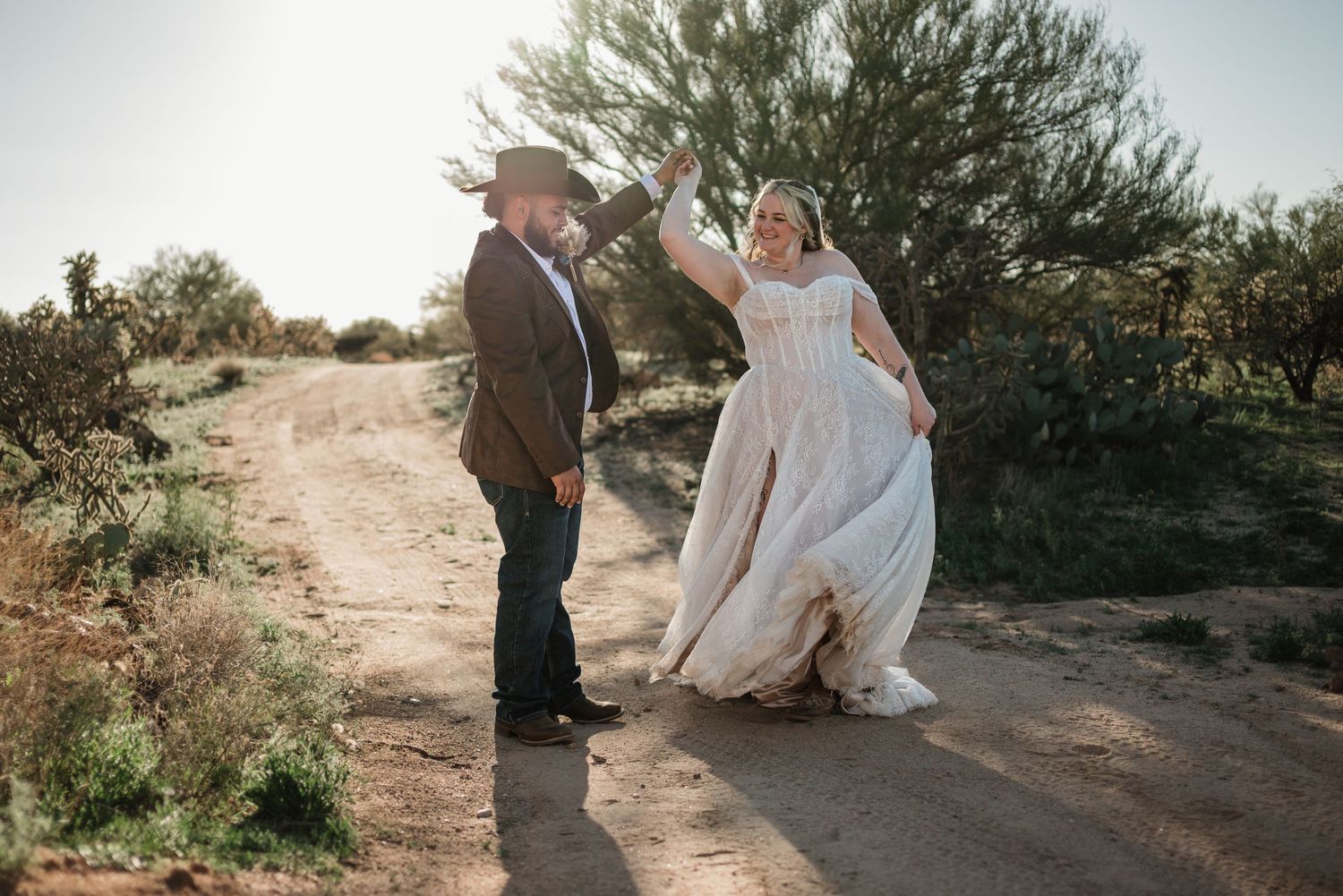 Newlyweds walking through an open desert during golden hour in Tucson Arizona at Sage Creek Ranch