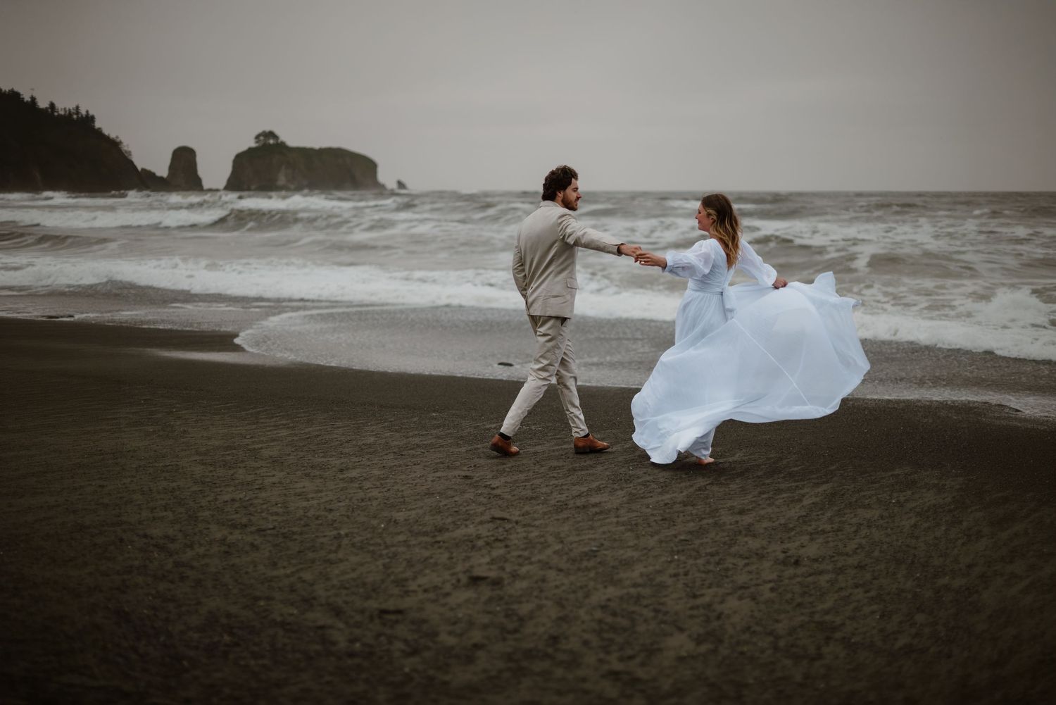 Couple running and playing on the beach in Washington during their elopement