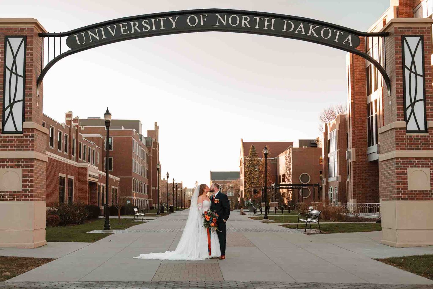 Couple embracing beneath the setting sun during their November North Dakota wedding
