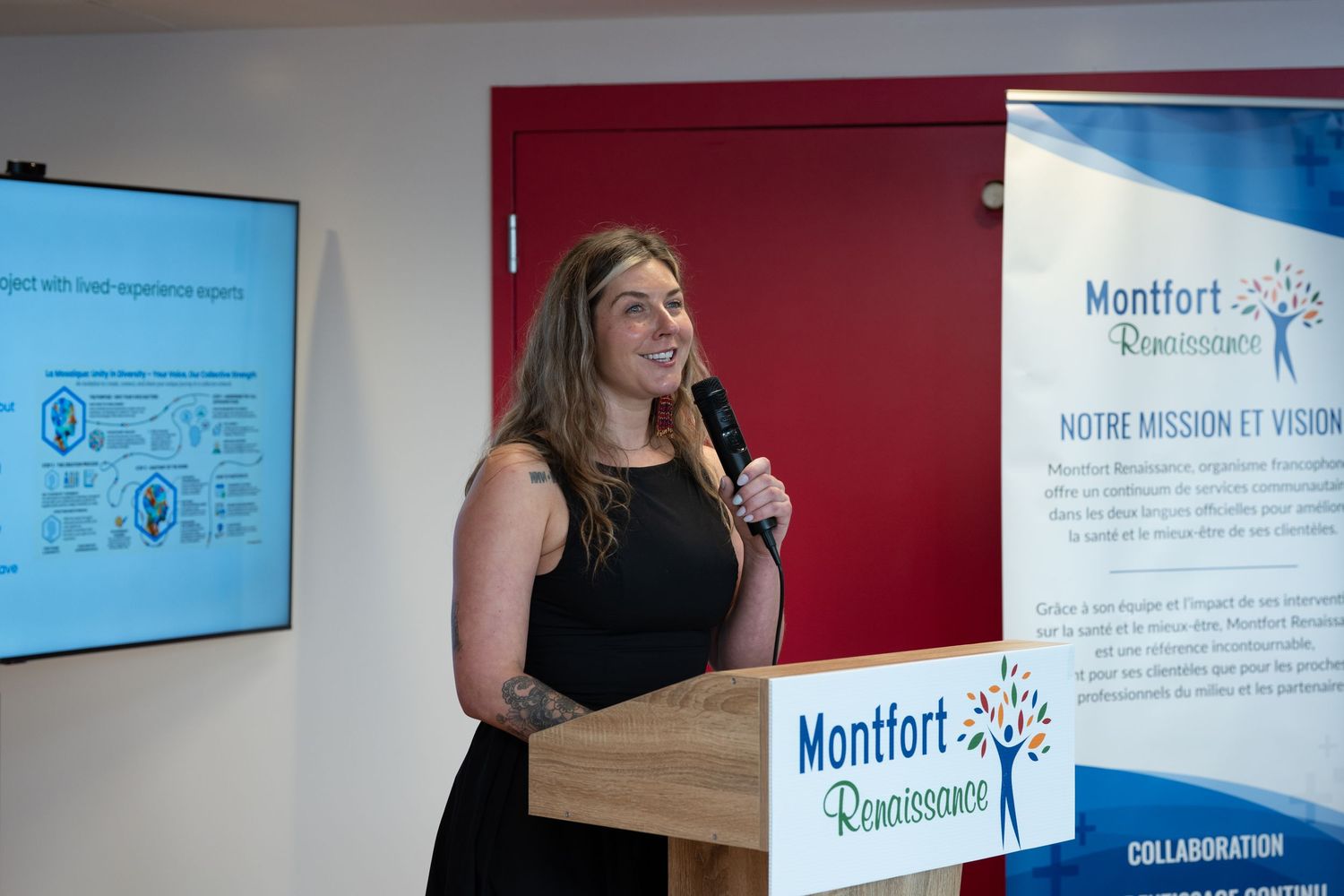 Woman speaking at podium during Montfort Renaissance organizational presentation event.
