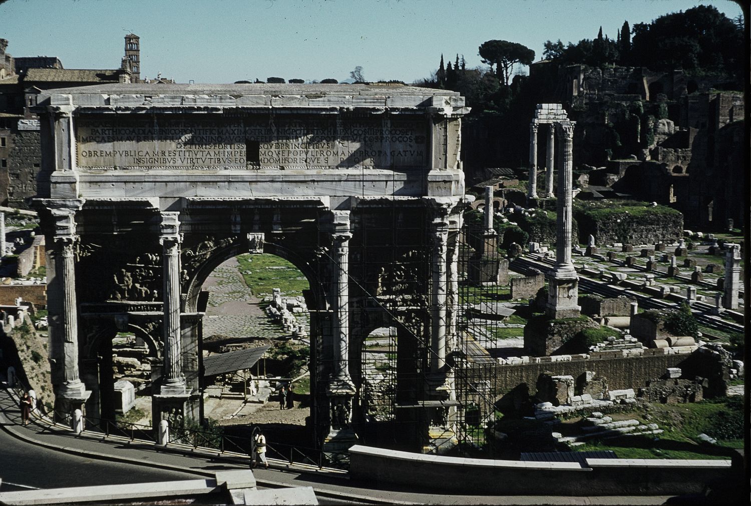 Ancient Roman triumphal arch ruins at the Forum Romanum with columns and historic structures.