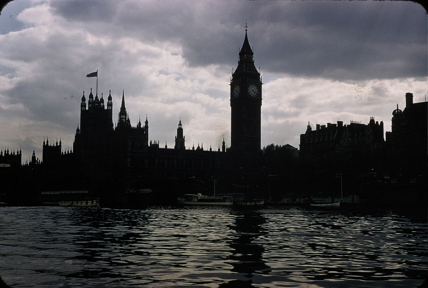 Dramatic silhouette of Big Ben and Houses of Parliament reflected on the River Thames at dusk.