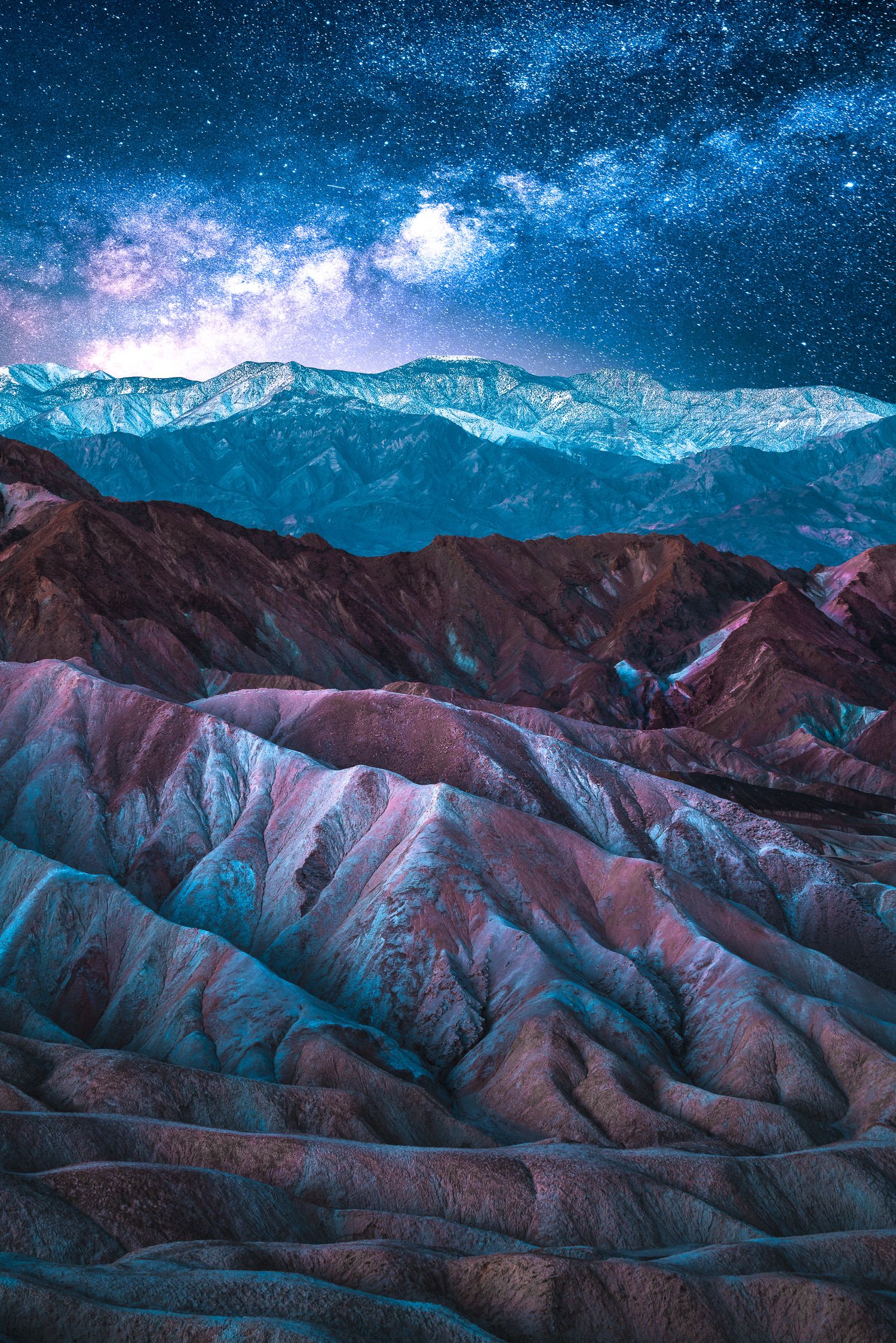 Stunning Milky Way galaxy over colorful badlands rock formations at night in Death Valley National Park.