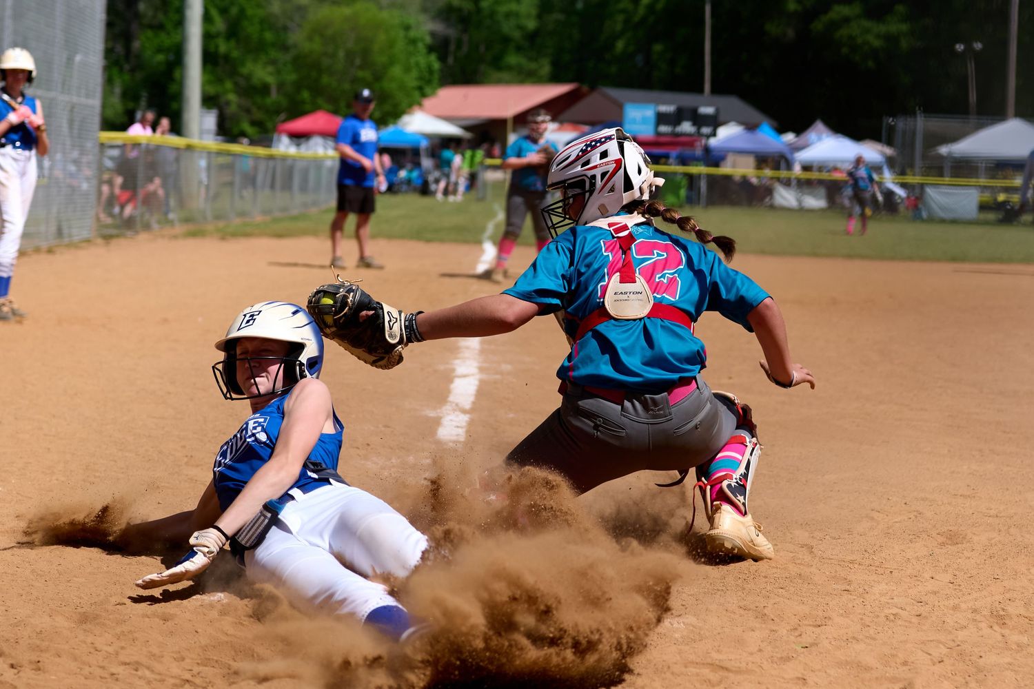 Youth softball player sliding into home plate during a close play