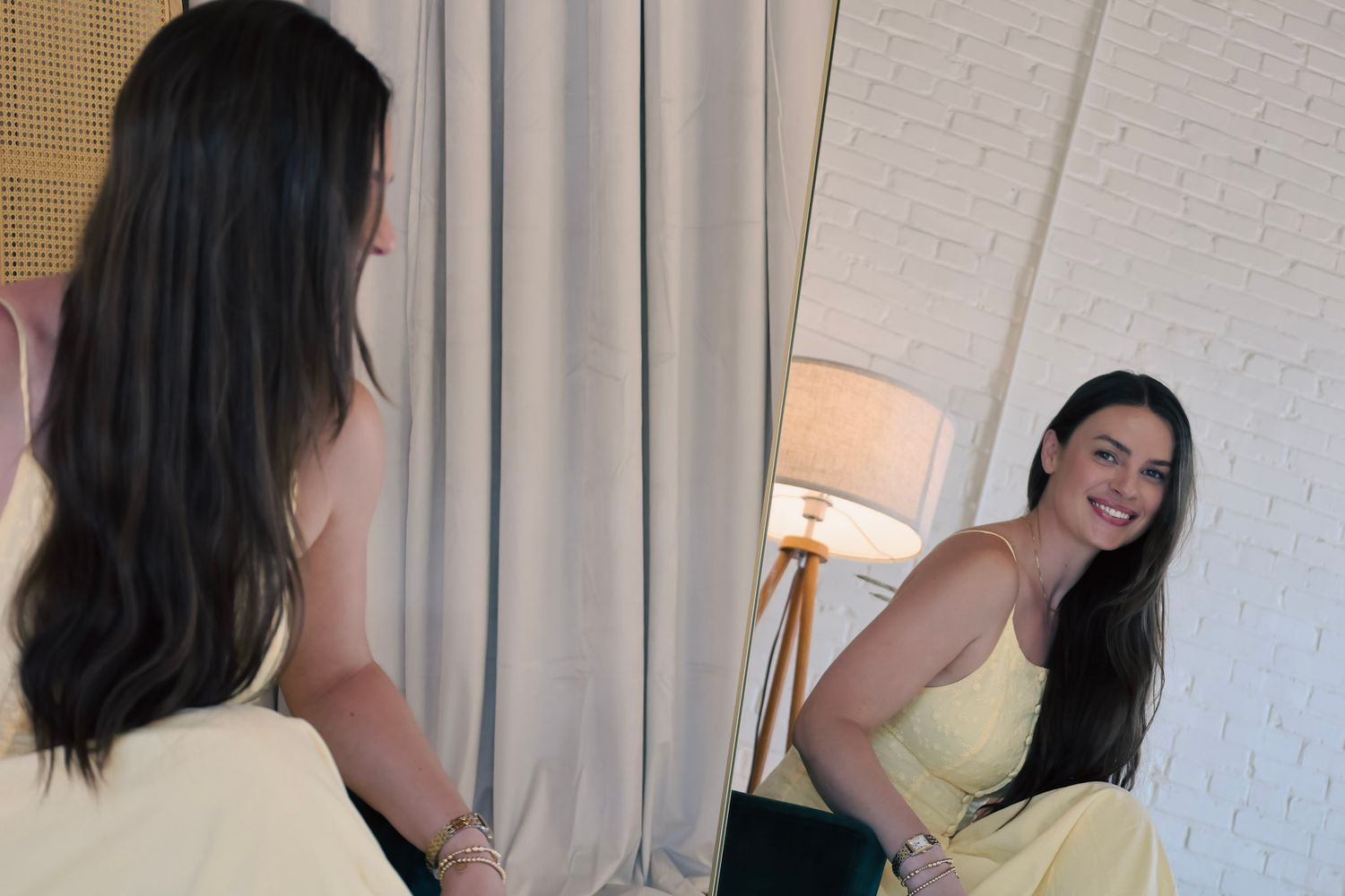 Woman in yellow dress smiling at her reflection in a mirror, standing in a bright modern room.