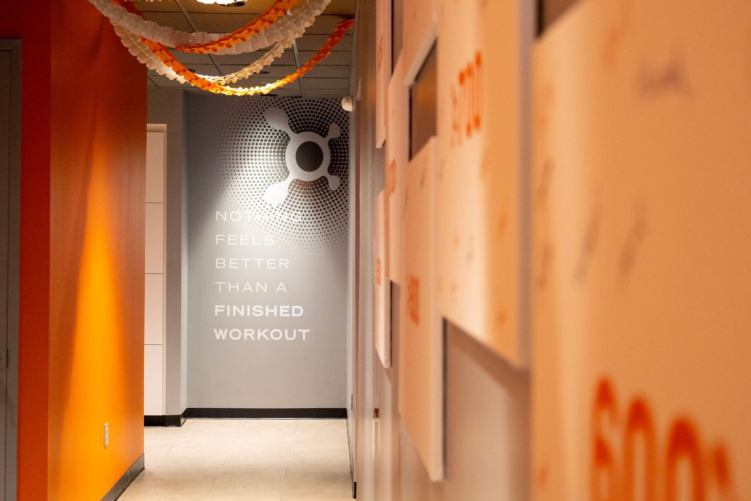 Motivational gym hallway with orange walls and quote 