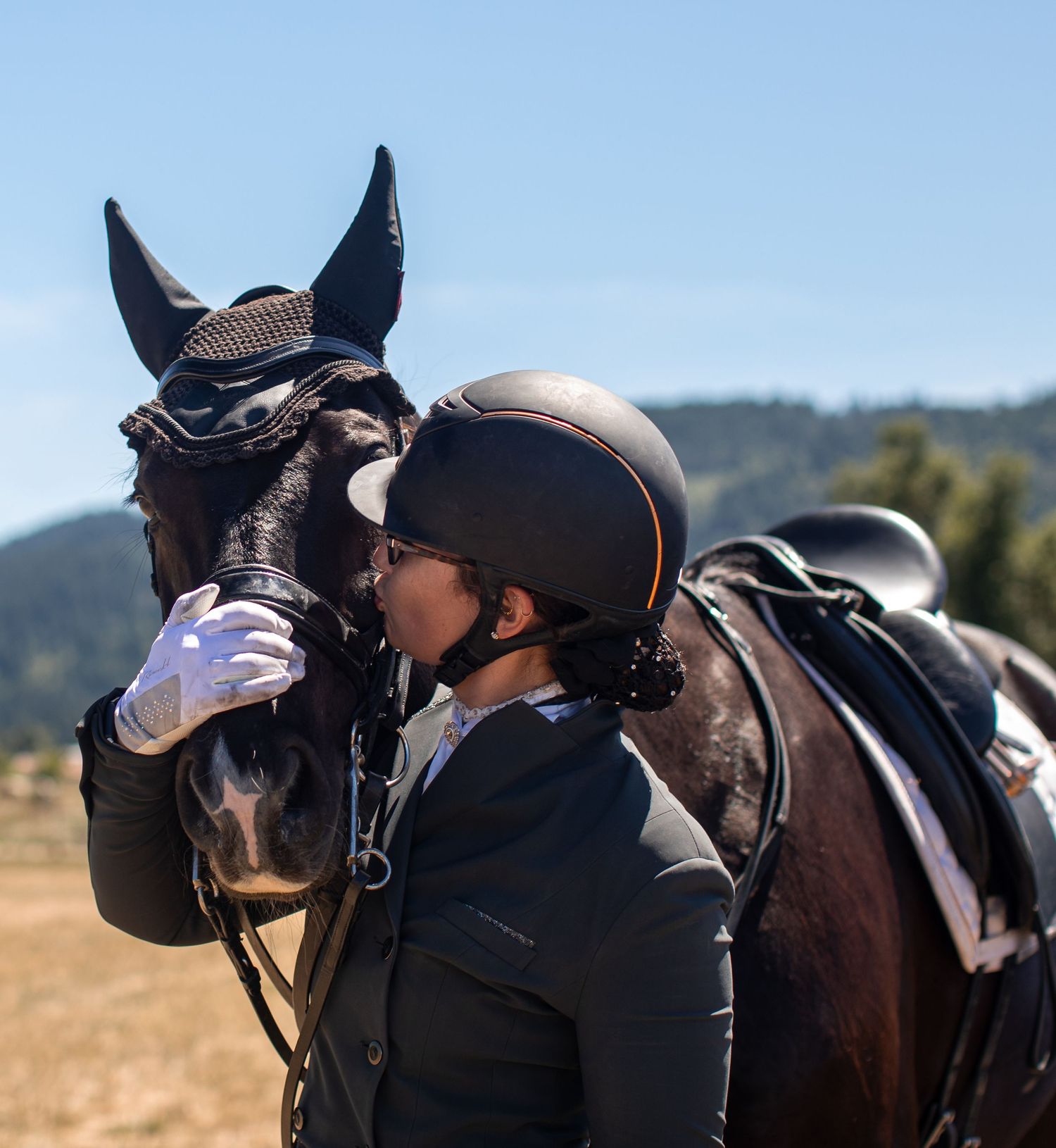 A rider gives her horse a kiss on the nose after they finish their ride.