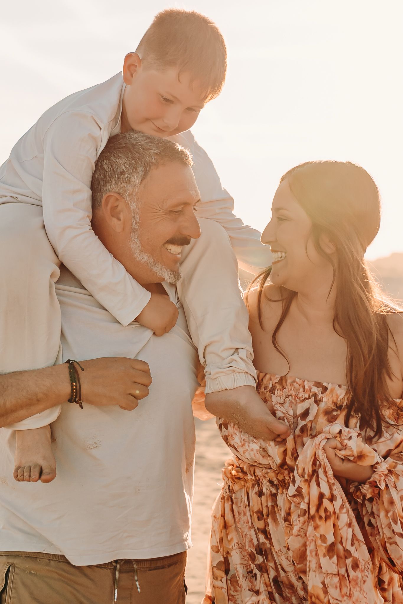 Familia disfrutando de una sesión de fotografía familiar espontánea al atardecer.