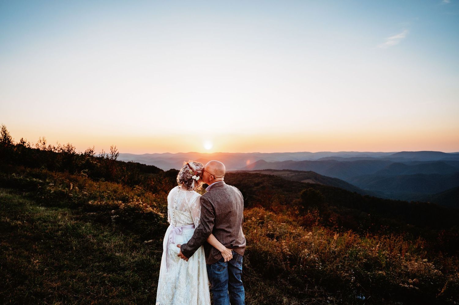 Older couple enjoy the sunset and grab each others butts at Fred Long Centennial Park in Thomas, WV. West Virginia Elopement photographer.