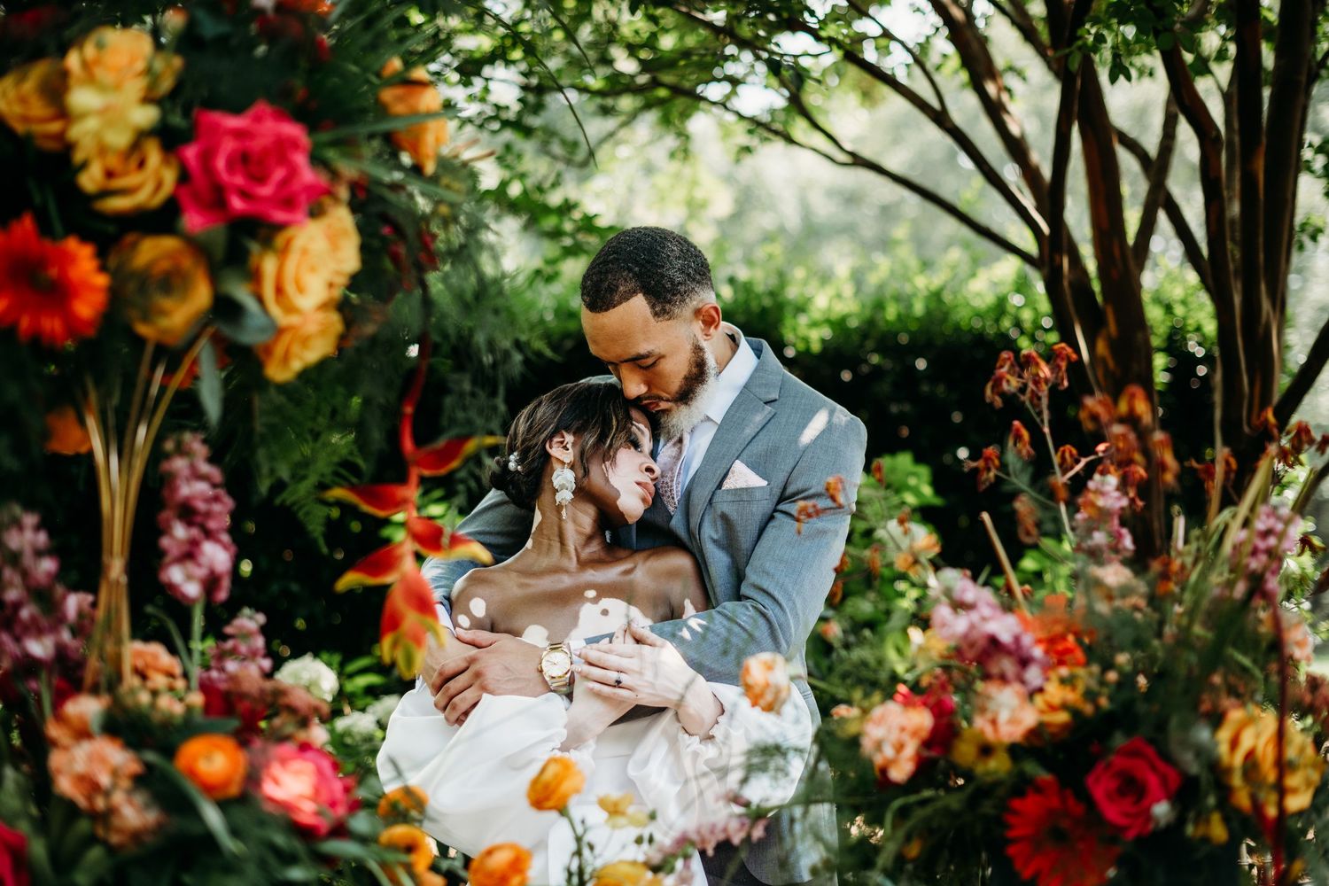 African American Bride and Groom with vitiligo pose among the flowerscape on their serpentine wedding table. Andrews Farms in Charlotte, NC