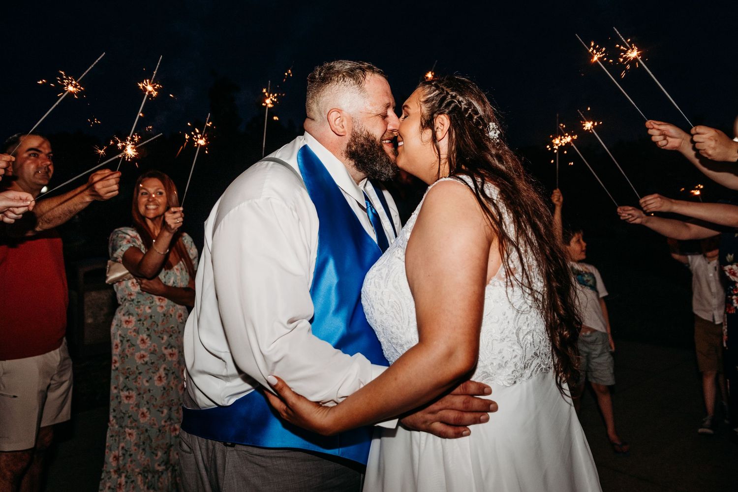 Bride and groom share an almost kiss under the sparklers held by friends and family outside Bridgeport Conference Center for their Wedding