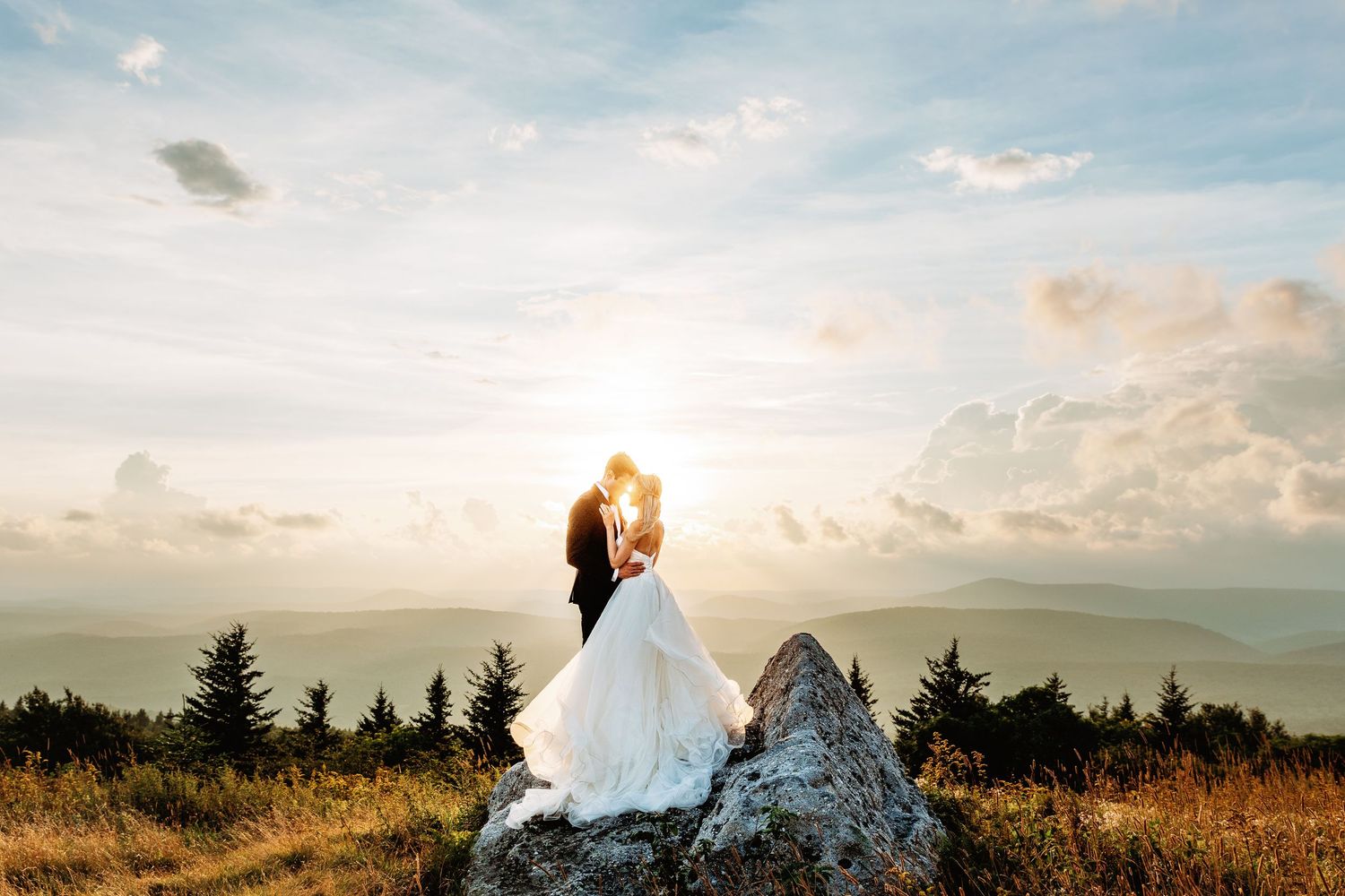 Bride and groom share a kiss at sunset in the field of Spruce Knob Mountain during their elopement | west virginia elopement photographer