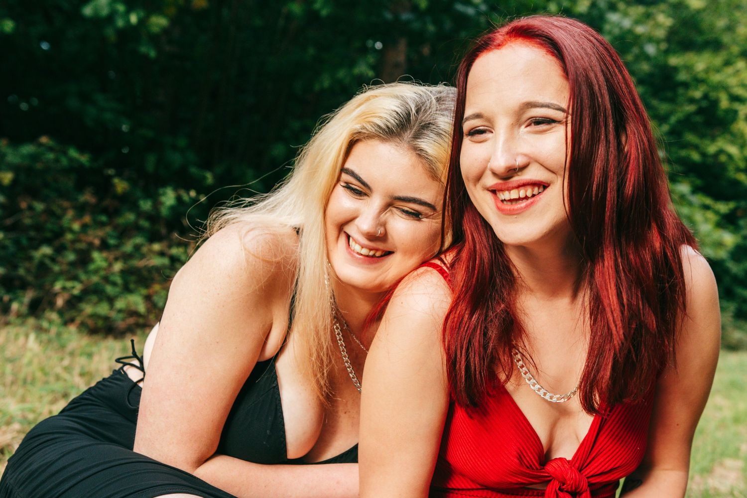 Friends laughing and embracing during an outdoor summer photoshoot.