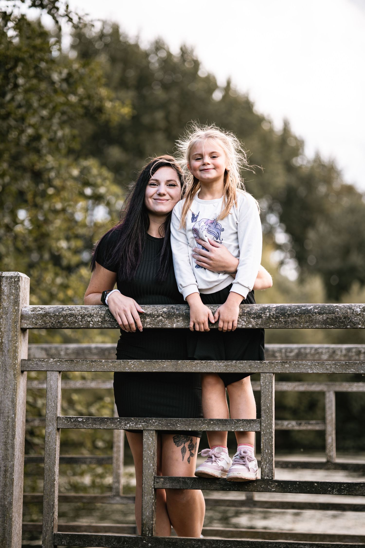 A playful moment captured on a wooden fence in a rustic outdoor setting with natural lighting.